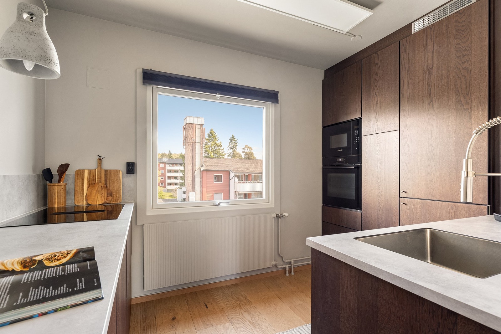 Kjøkkeninnredningen er utstyrt med innredning i brune, glatte fronter, benkeplate i laminat og nedfelt kum i rustfritt stål. Galleribilde