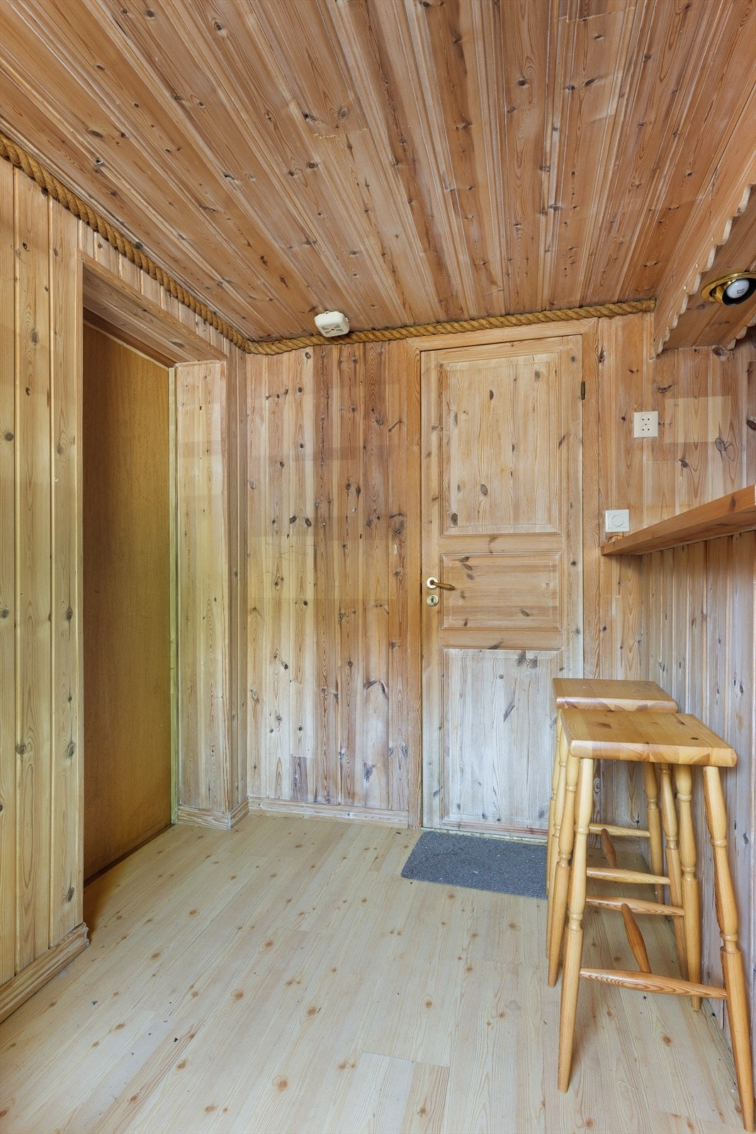 Overflater med trepanel på vegger og laminat på gulv i deler av kjelleren. Galleribilde