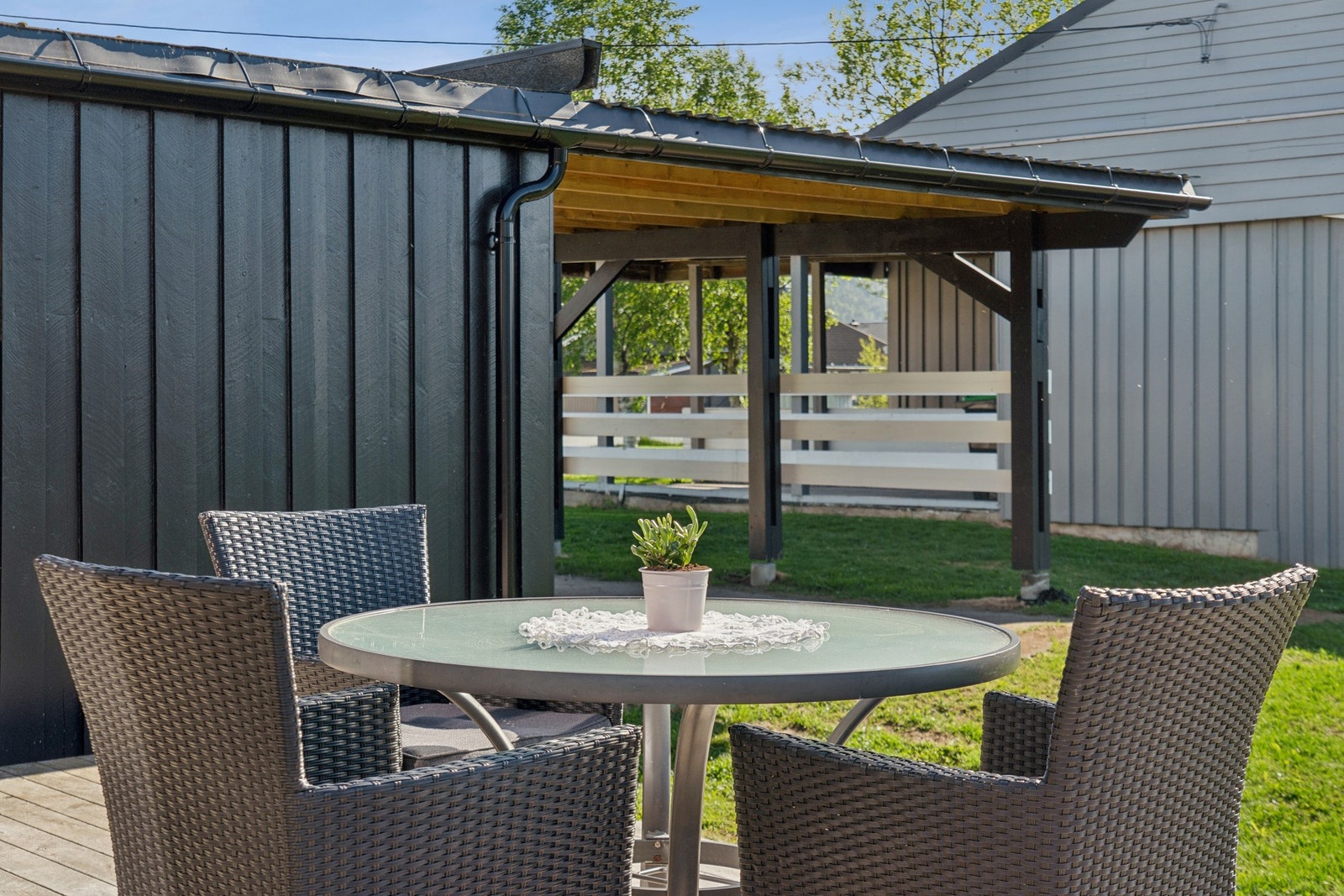 Uteplass med plass til sittegruppe ved siden av carporten. Galleribilde