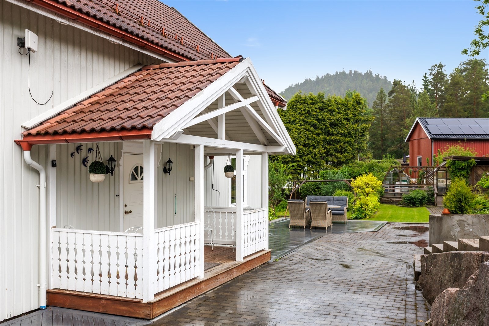 Overbygd inngangsparti med terrasse og utebelysning. Galleribilde