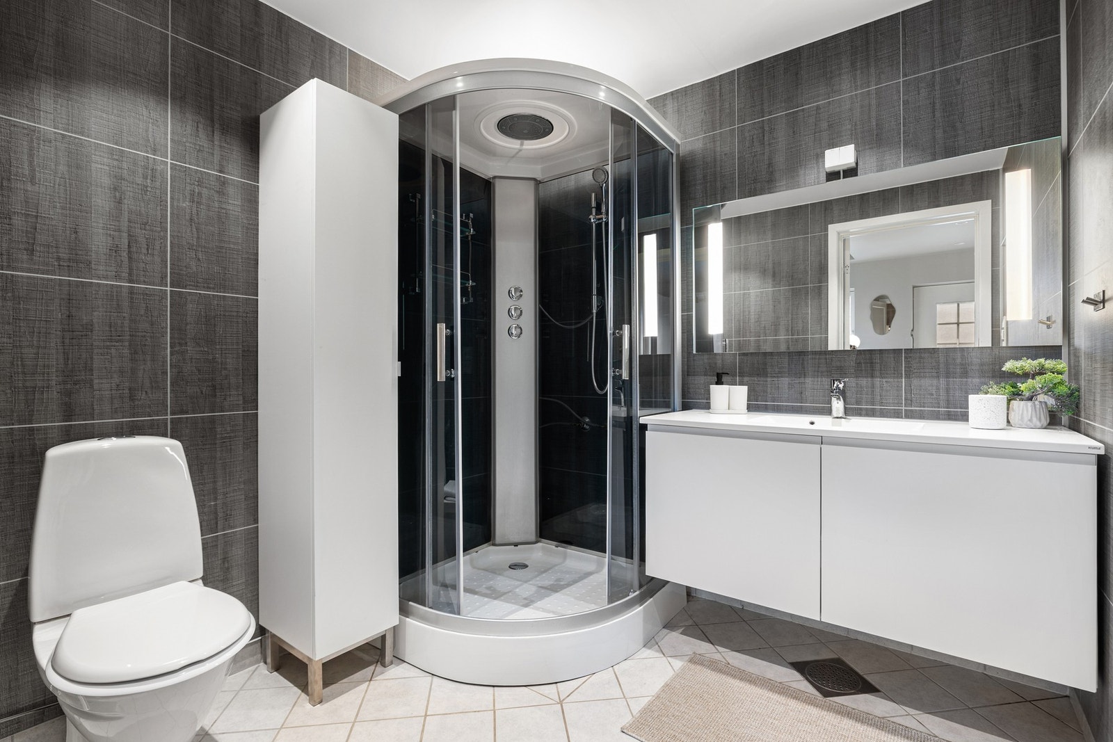 Flislagt bad på ca. 5 kvm. Badet ble oppgradert med ny servant og dusjkabinett i 2026. Galleribilde