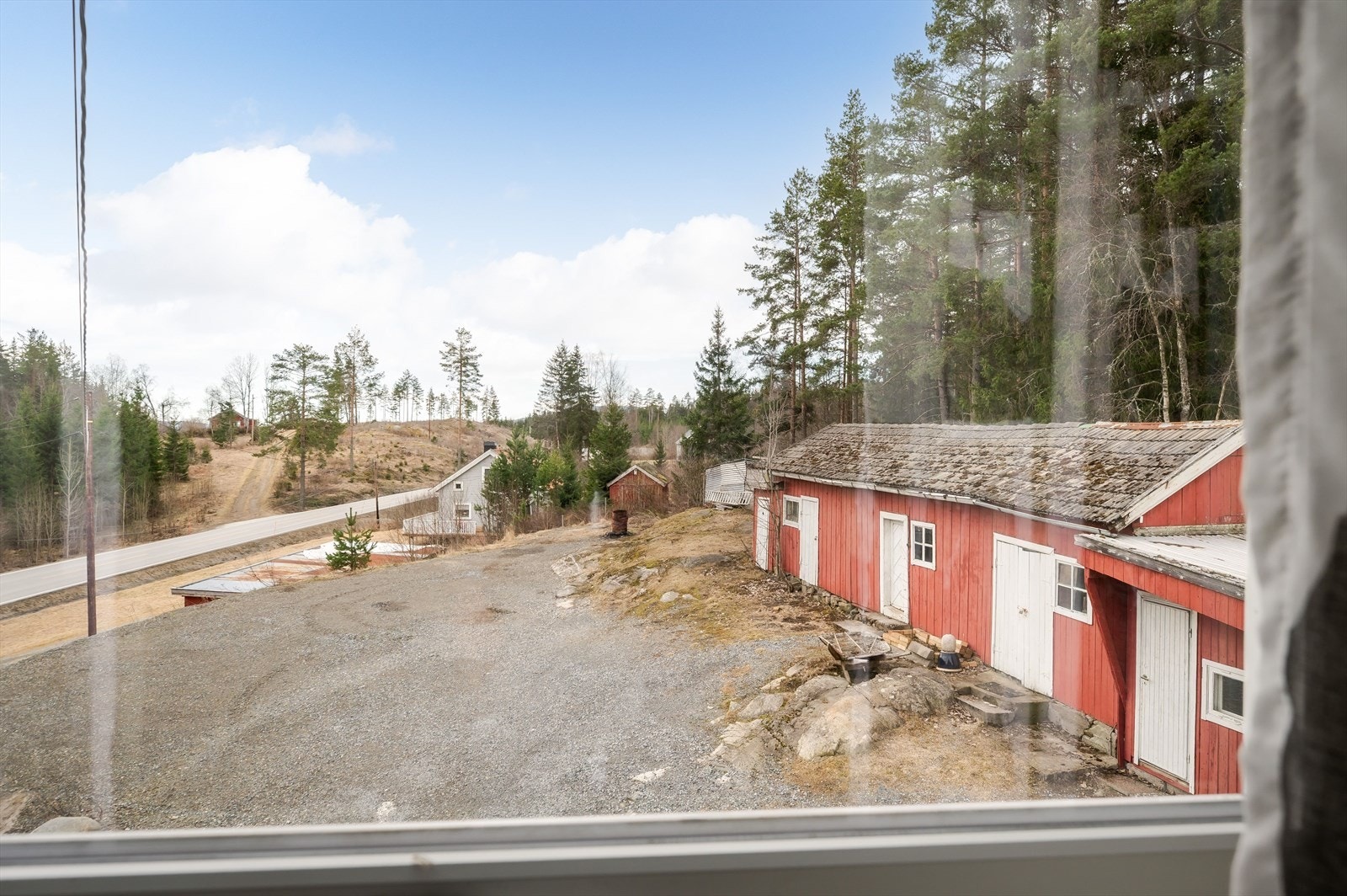 Eiendommen har en eldre garasje og uthus av treverk, begge med lav standard og behov for vedlikehold. Galleribilde