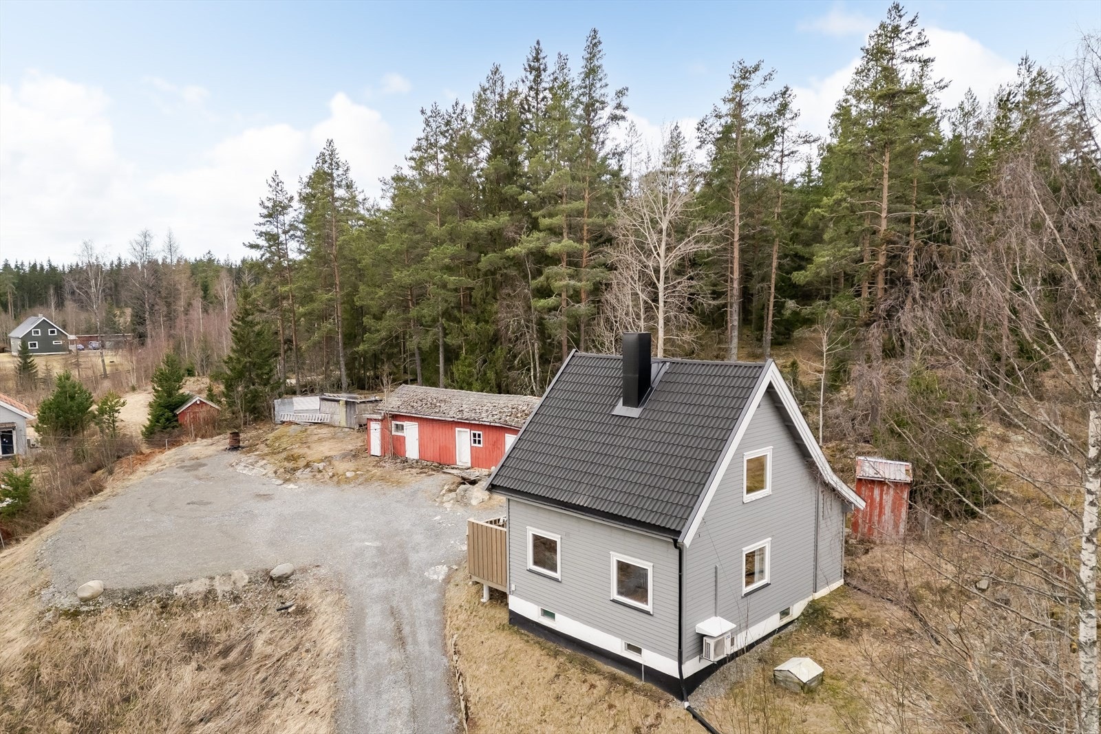 Eiendommen ligger i skrånende terreng med privat innkjørsel og god plass til parkering rundt huset. Galleribilde