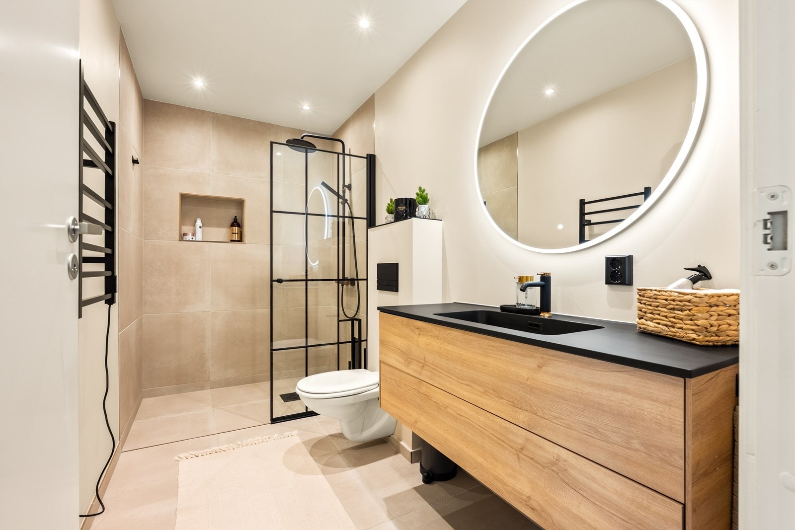 Badet er holdt i tidsriktige farger, med stor dusjnisje og moderne innredning Galleribilde