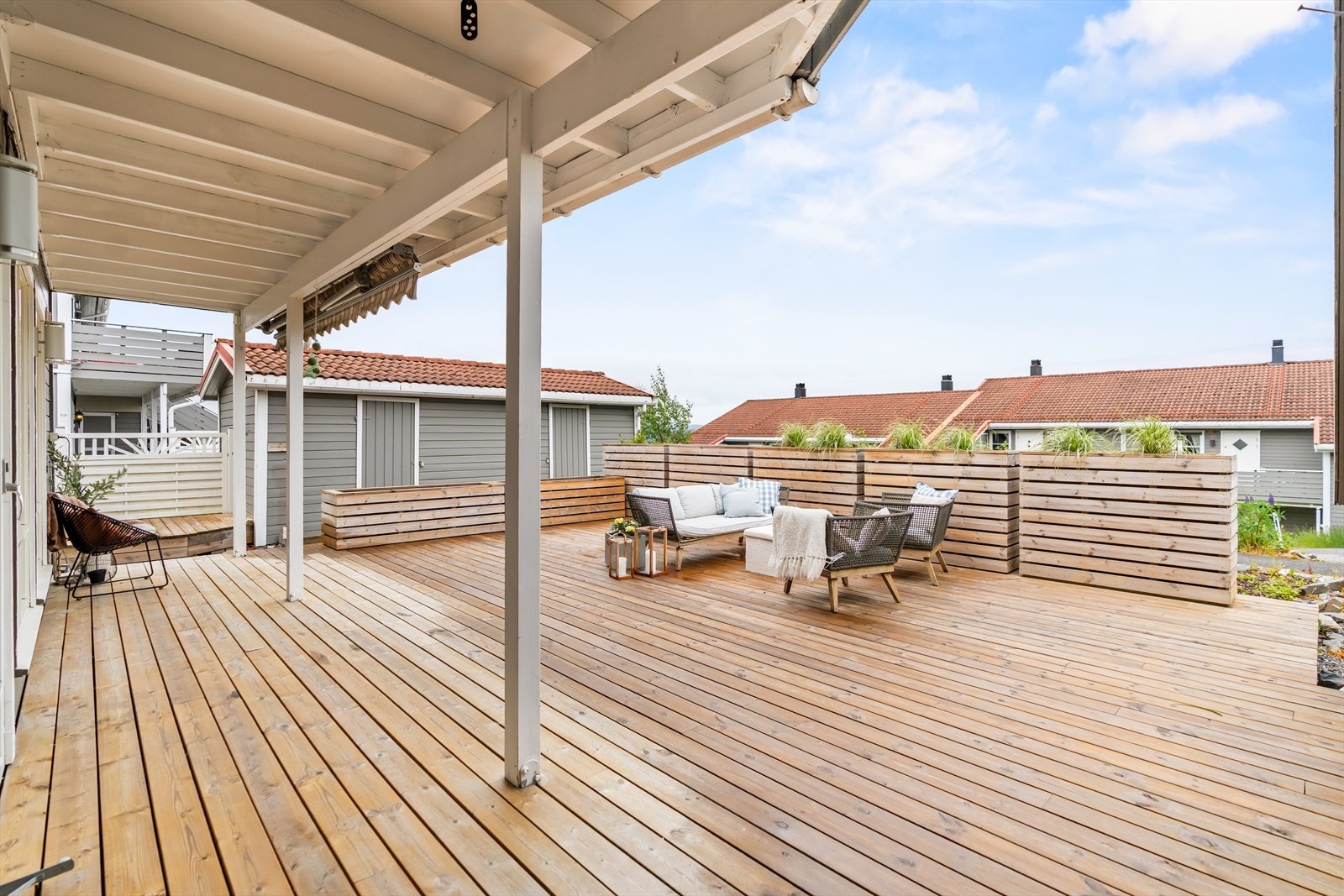 Terrasse med romslig overbygg som gir gode bruksmuligheter gjennom store deler av sesongen. Her er det plass til både spisegruppe og lounge. Galleribilde