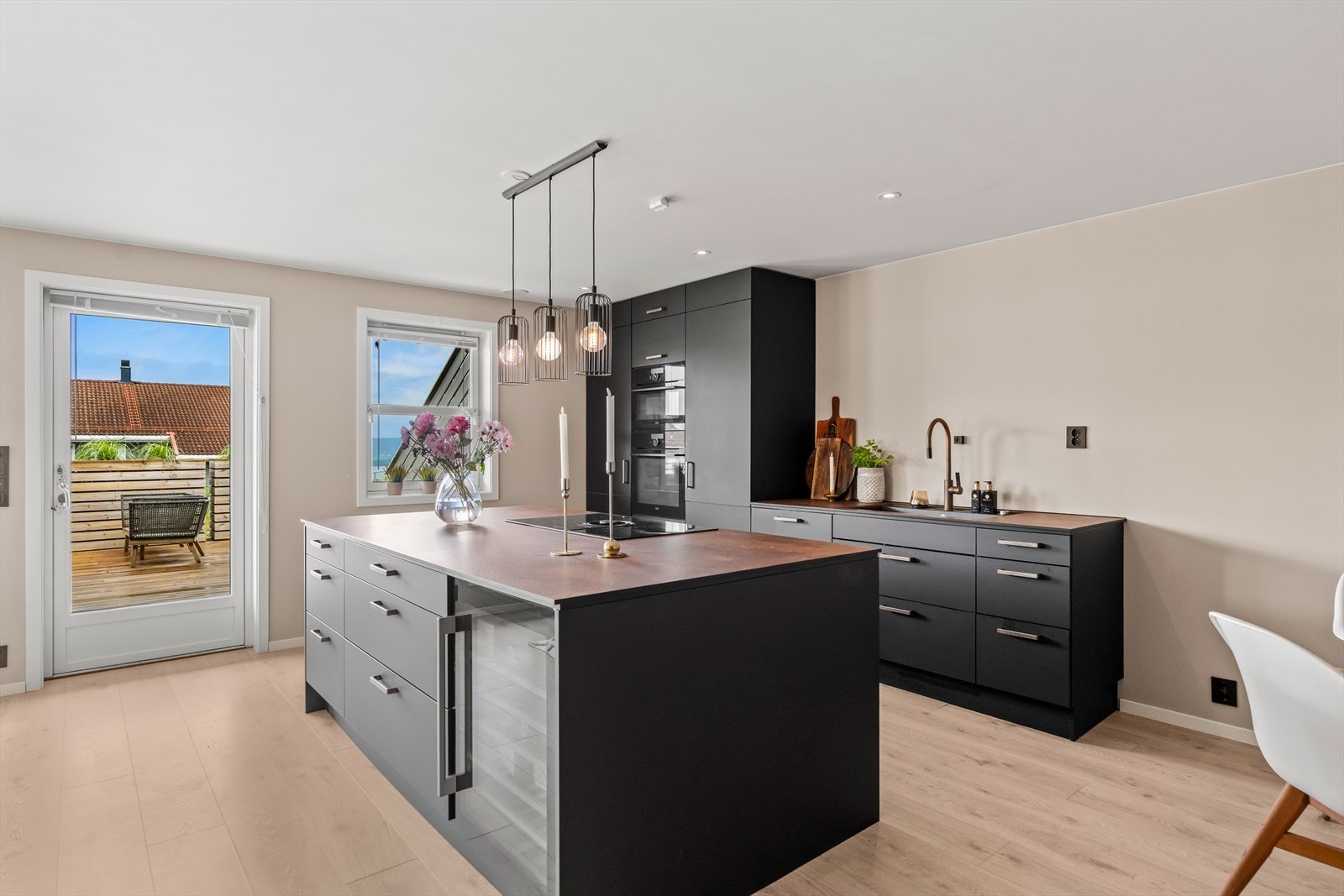 Kjøkkenet fremstår moderne og gjennomført, med mørke fronter og varme detaljer. God benkeplass og smarte løsninger gjør dette til et kjøkken som fungerer like godt til hverdag som til gjester. Galleribilde