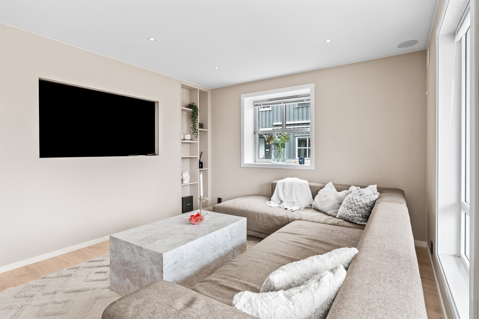 Romslig sofakrok med god plass til stor sofa og medievegg. Den lyse stuen gir et luftig og hjemmekoselig førsteinntrykk. Galleribilde
