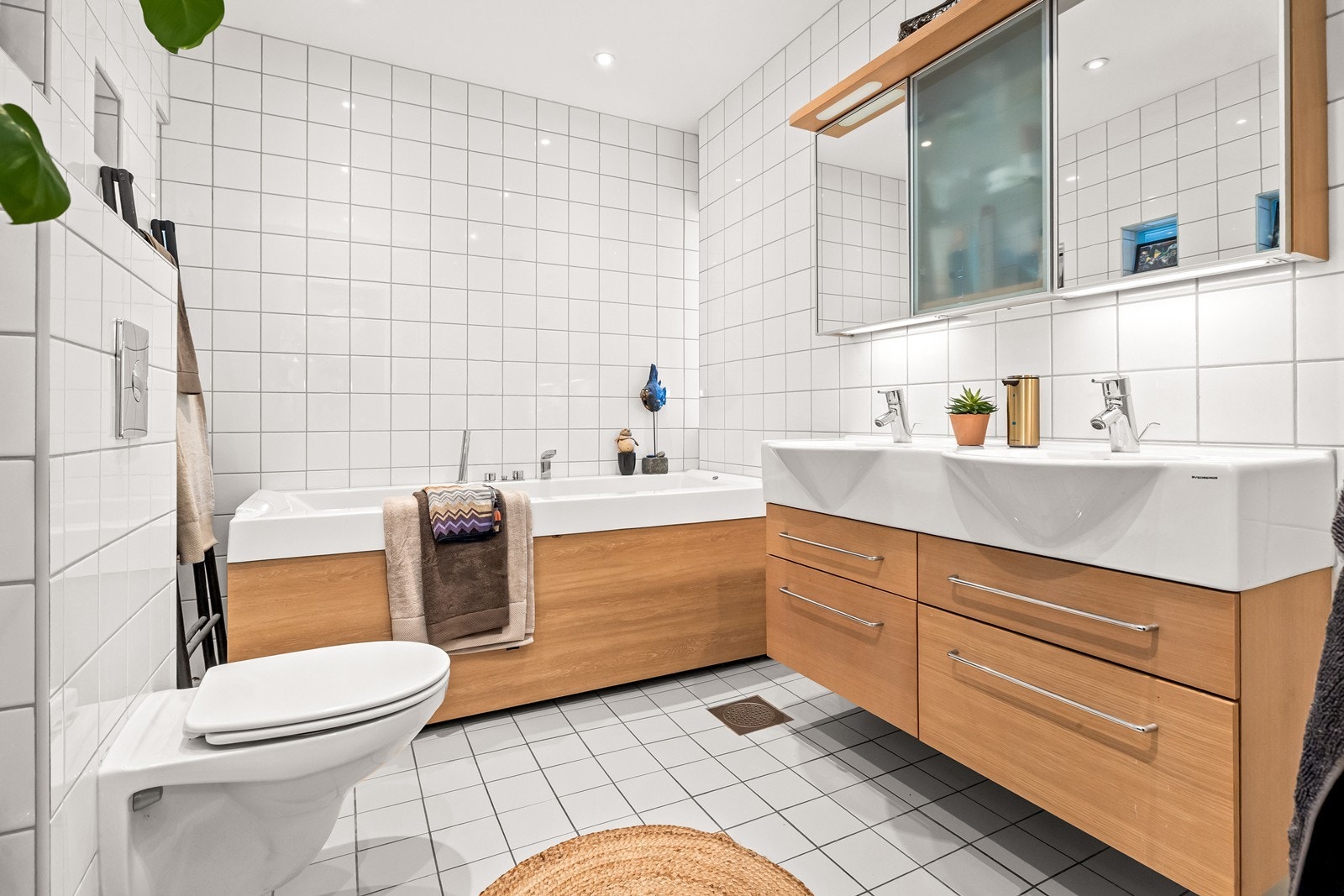 Bad i 1. etg. har delikate kombinasjoner av hvitt og trefarge med gulvvarme og downlights. Badekar innbyr til avslappende stunder så vel som badetid med barna. Galleribilde
