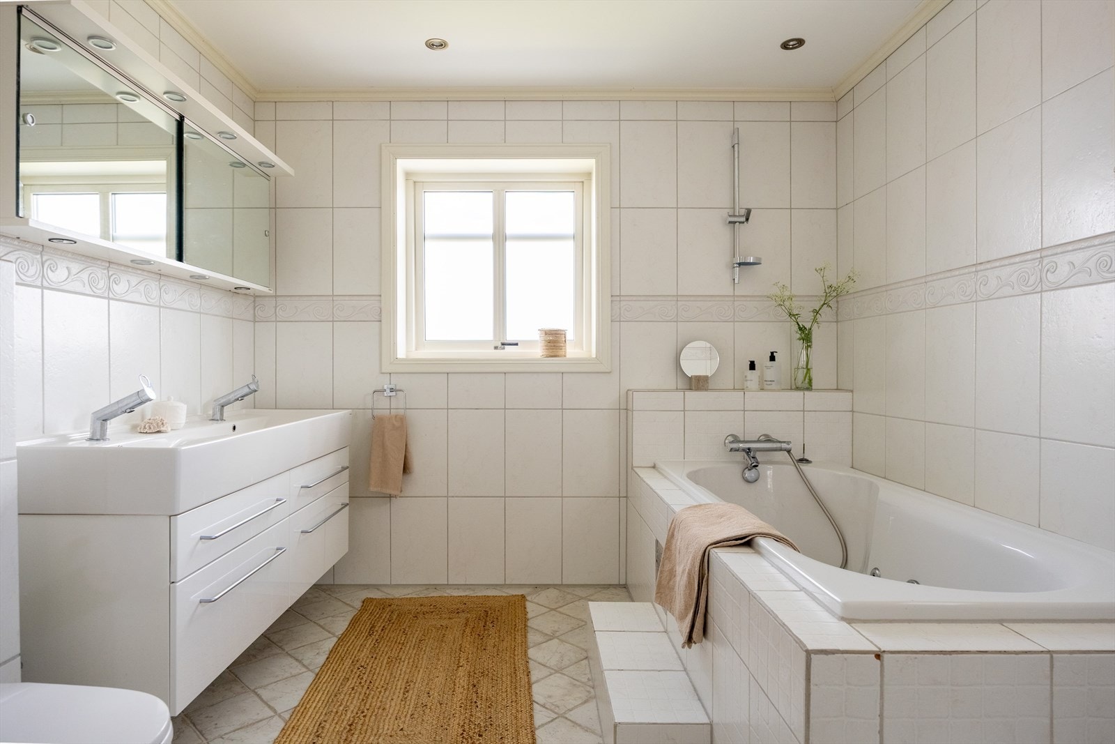 Badet i første etasje er utstyrt med et herlig badekar og lys baderomsinnredning med dobbelservant. Galleribilde