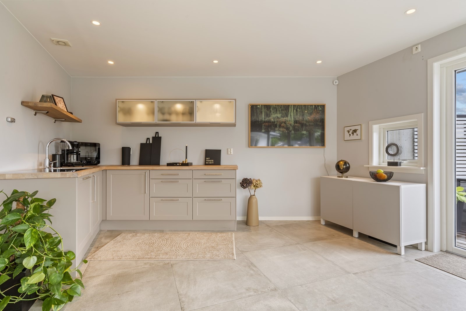 Tidsriktig kjøkken i hagestuen med oppvaskmaskin, koketopp, blandebatteri og kum. Galleribilde