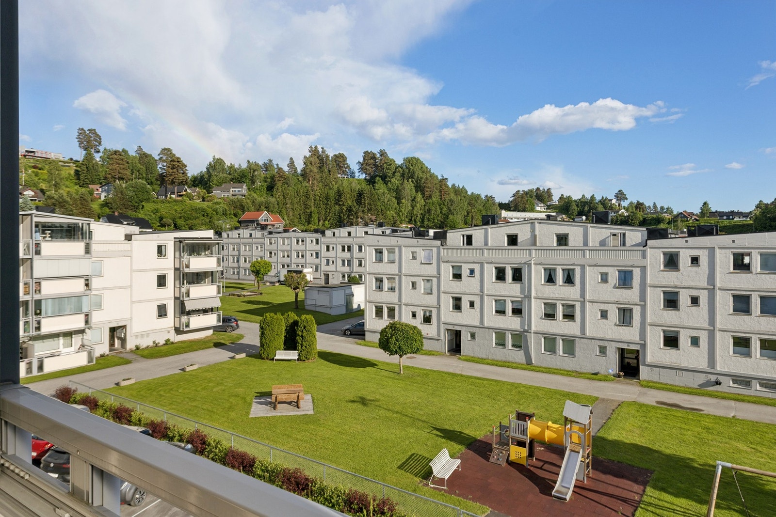 Utsikten fra balkongen. Her kan du se utover borettslagets fasiliteter. De fine grøntarealene som kan benyttes av beboerne. Galleribilde