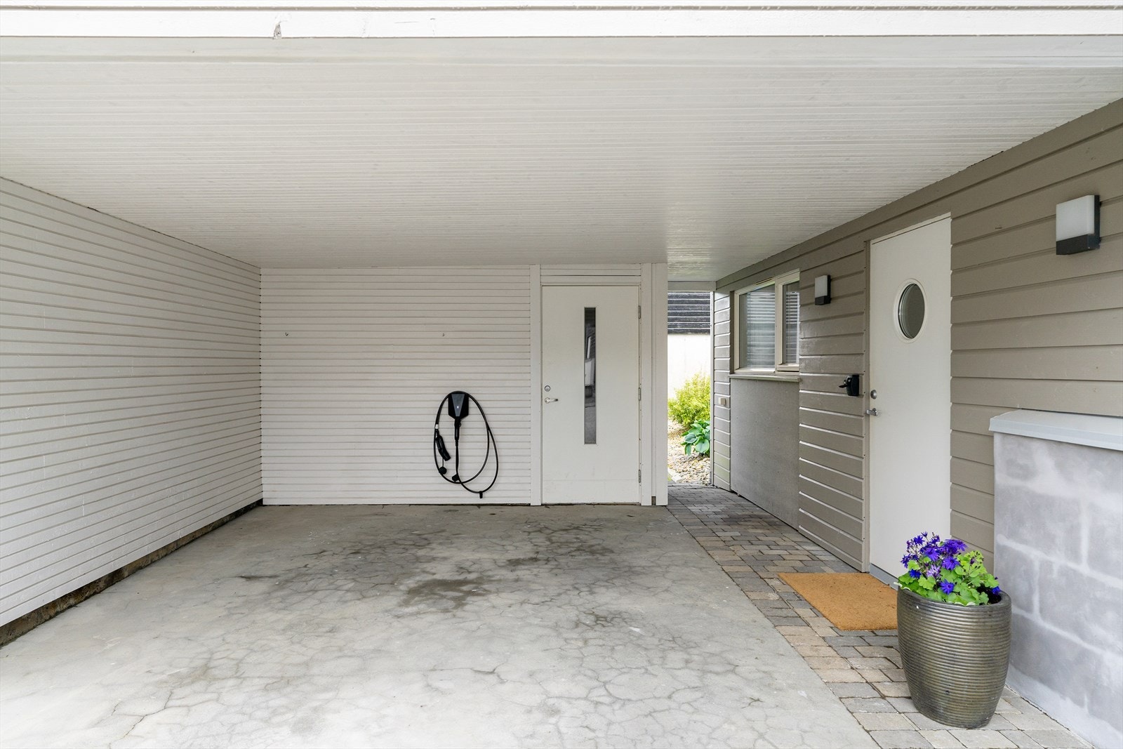 Carport med elbillader og tilhørende bod for ekstra lagring. Galleribilde