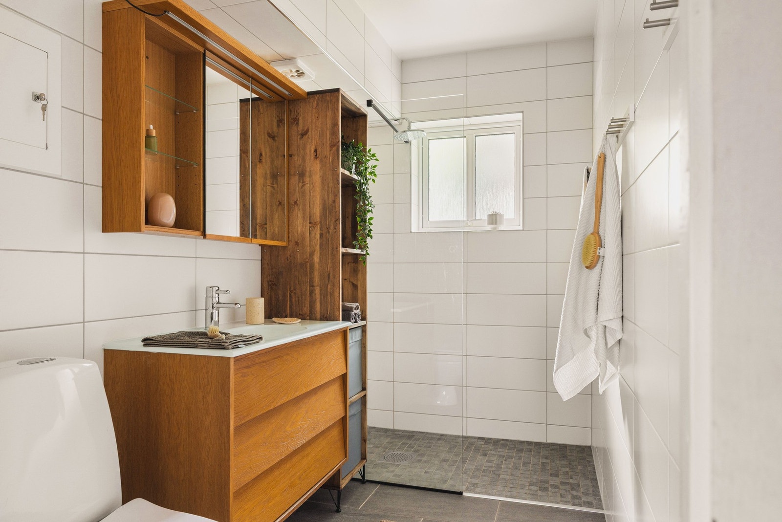 Badet er ca. 4,6 kvm og har flislagte overflater, malt tak og varmekabler i gulv. Galleribilde