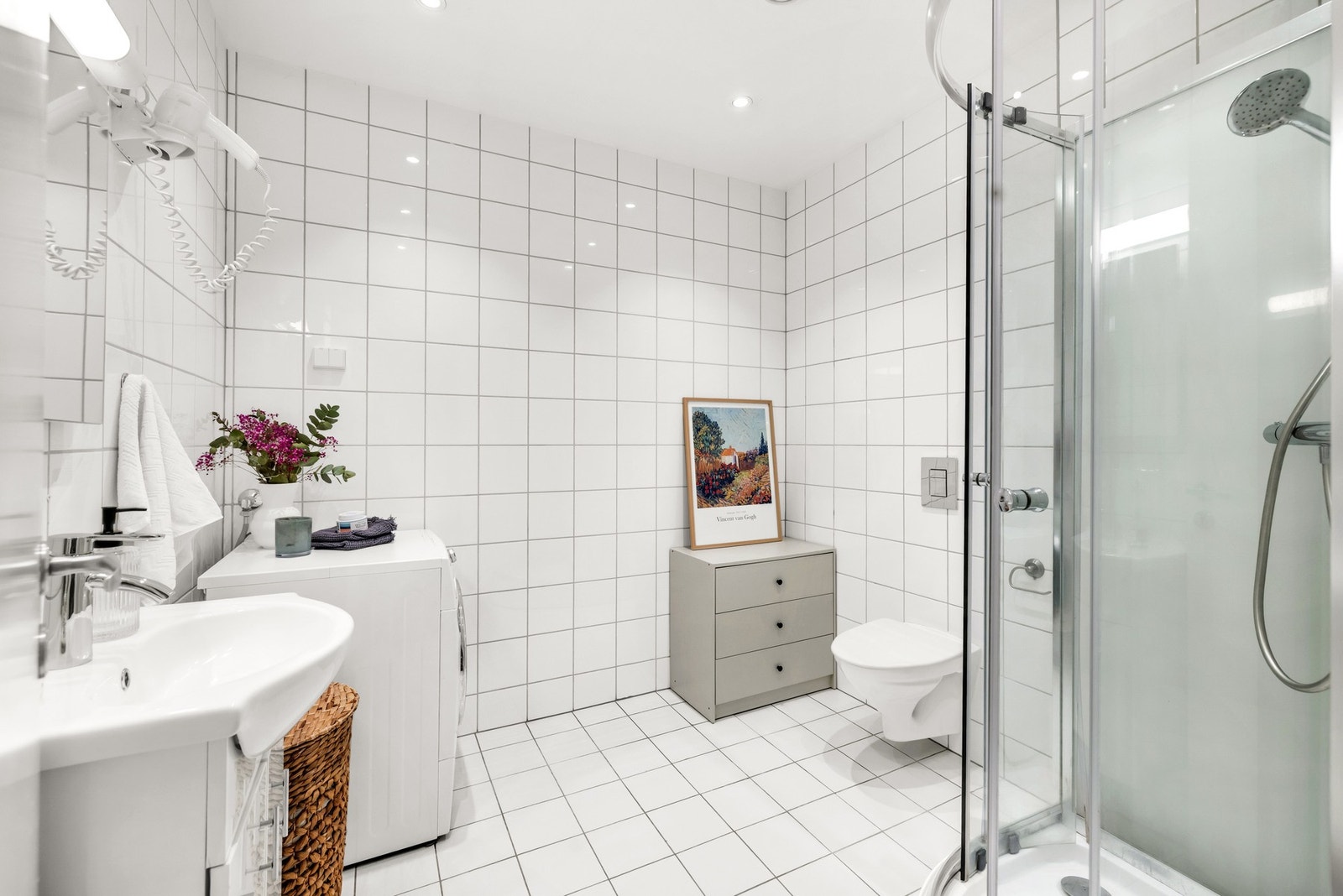 Lyst og pent baderom med hvite fliser på gulv og vegger. Galleribilde