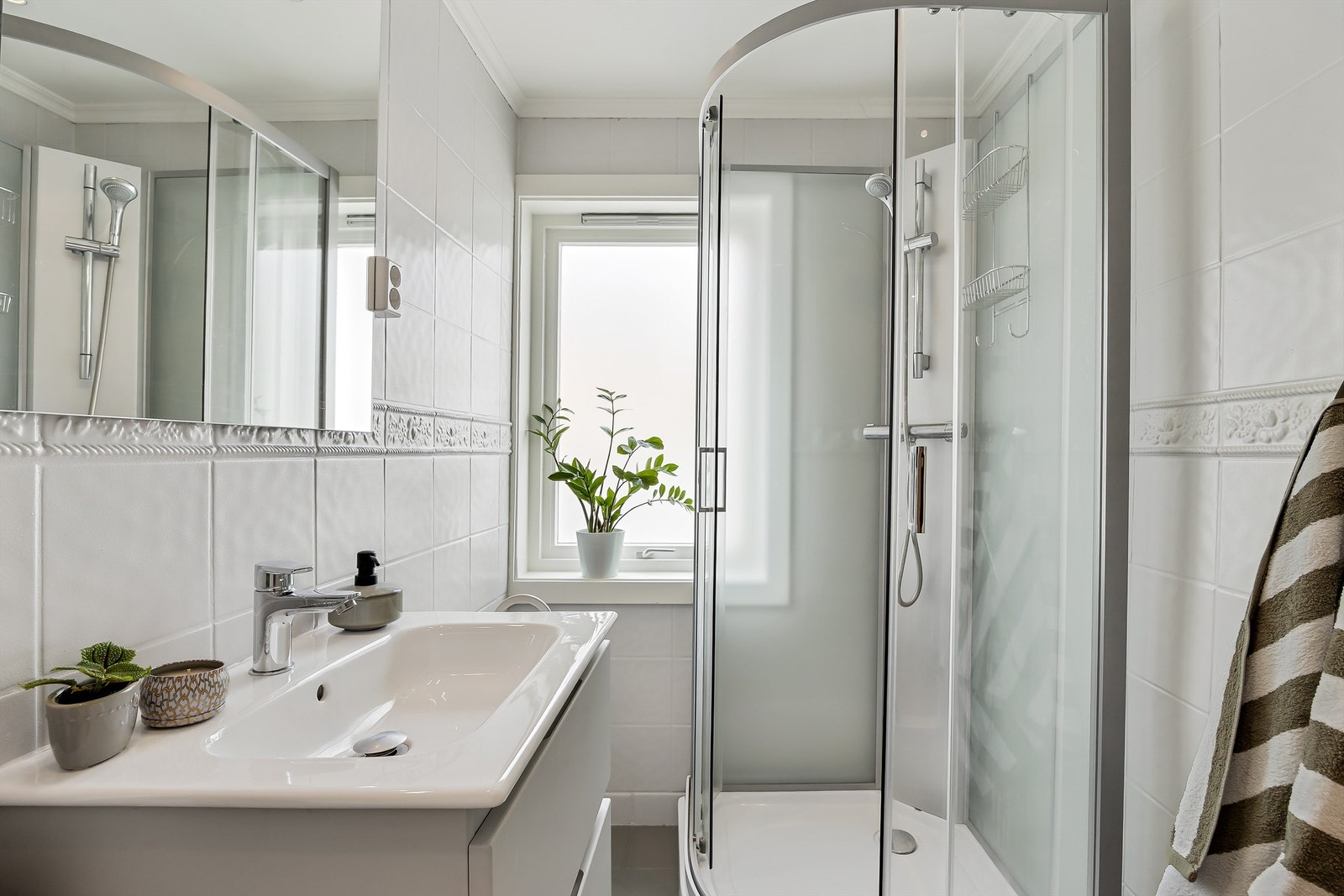 Badet er innredet med dusjkabinett, servantinnredning og speil med belysning. Varmekabler i gulv for økt komfort. Galleribilde