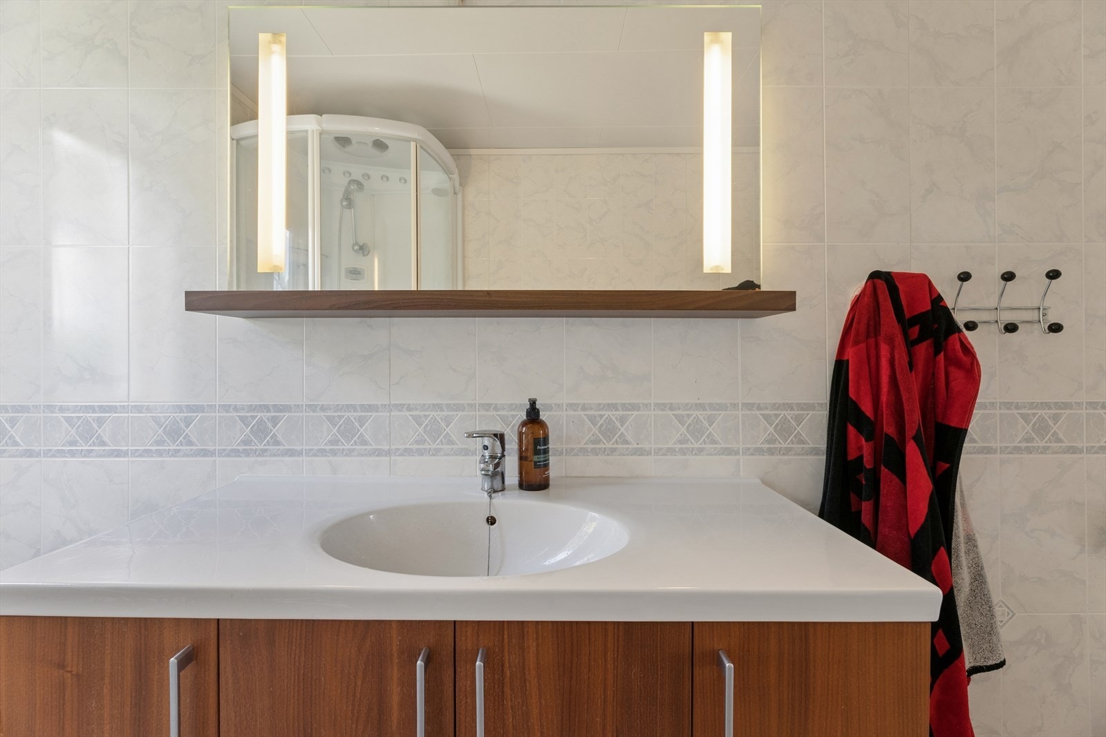 Baderomsinnredning med heldekkende servant og god oppbevaringsplass. Badet har et oppgraderingsbehov. Galleribilde