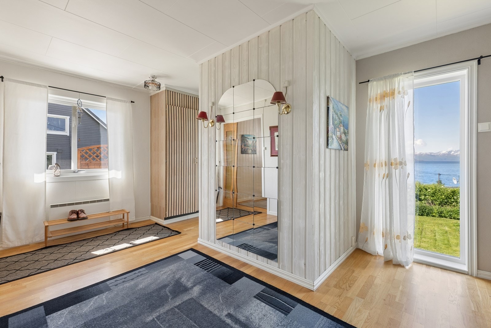 Hallen oppleves som åpen og godt proporsjonert, med parkett på gulvet og en frittstående skillevegg. Galleribilde