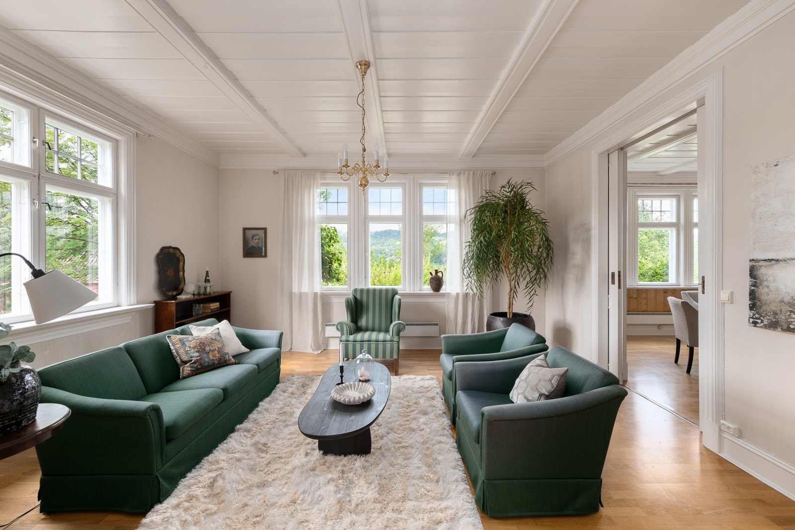 Parkett på gulvet og panel i taket er gjennomgående i oppholdsrommene. Galleribilde