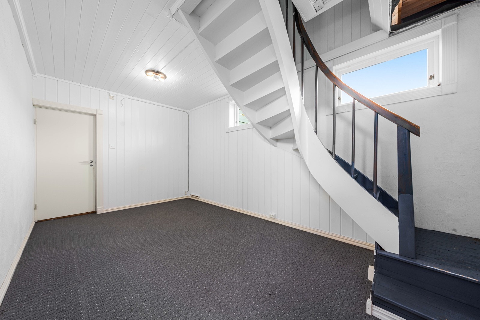 Malt tretrapp med tette opptrinn forbinder de to etasjene. Galleribilde