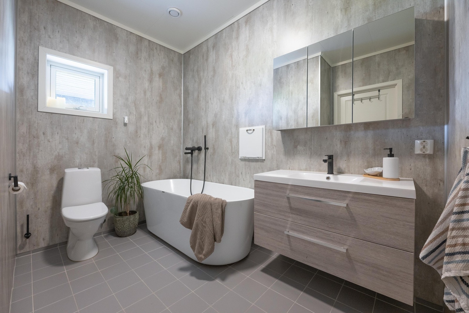 Badet i første etasje er ca. 6,4 m² og har flislagt gulv med elektriske varmekabler, baderomsplater på vegger og himlingsplater i tak. Galleribilde