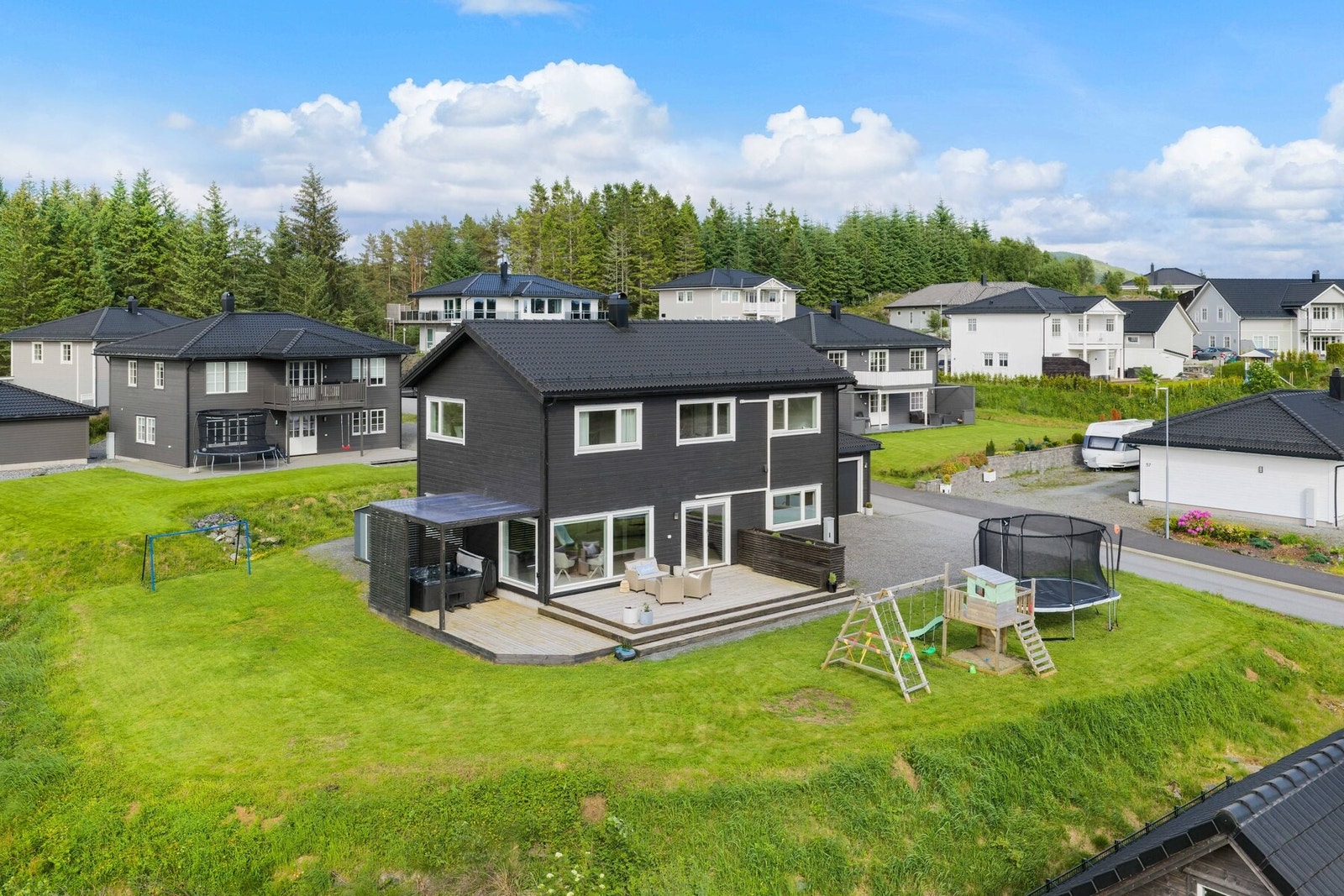 Utvendig kan eiendommen by på en stor terrasse, plenareal, jacuzzi og gode uteområder med fin kontakt mot grønne omgivelser. Galleribilde