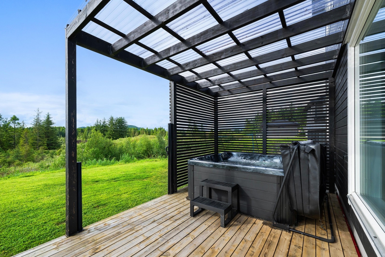 Det er også etablert en overbygd terrassedel hvor det i dag er plassert jacuzzi. Dette gir en lun og skjermet sone med gode bruksmuligheter gjennom store deler av året. Jacuzzi medfølger ikke automatisk, men kan eventuelt avtales særskilt. Galleribilde