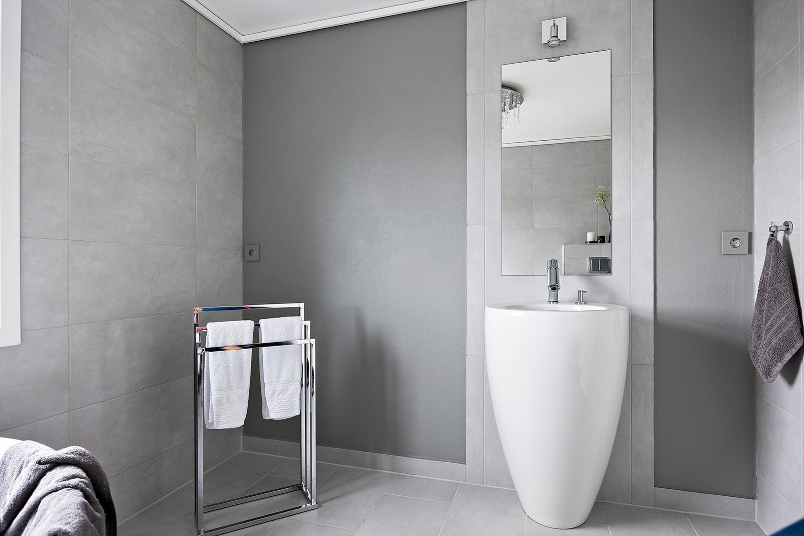 Badet har fliser på gulv og en kombinasjon av fliser og tapet på veggene. Galleribilde