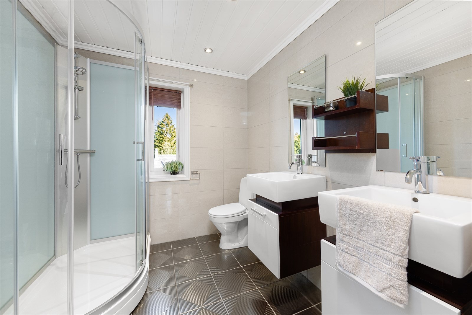 Badet i 1. etasje er innredet med toalett, dusjkabinett og 2 servanter med innredning og speil. Galleribilde