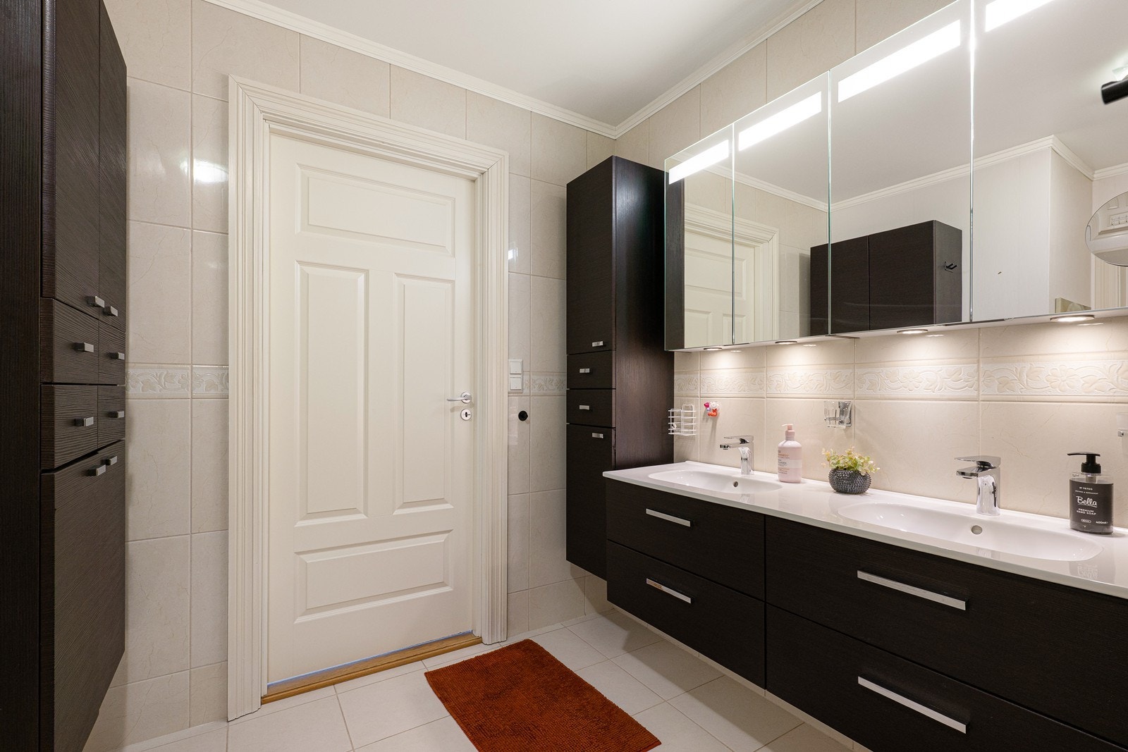 Badet har sandfargede fliser på gulv og vegger og gulvvarme. Galleribilde
