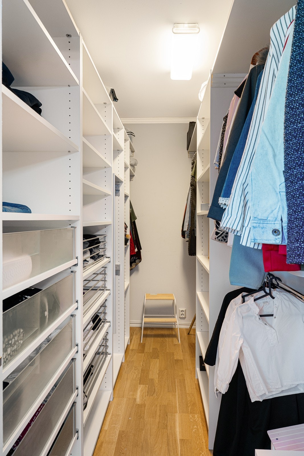 Garderoben har godt med oppbevaringsplass i hvit innredning på to sider av rommet. Galleribilde