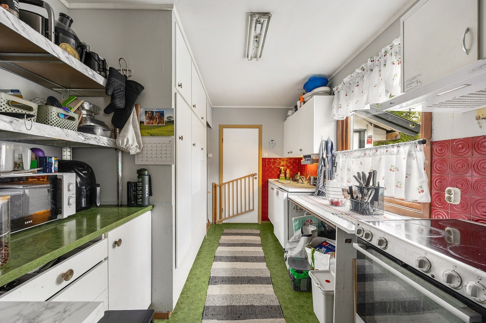 Det ene av etasjens to kjøkken, innredet med glatte fronter og benkeplate i laminat. Galleribilde