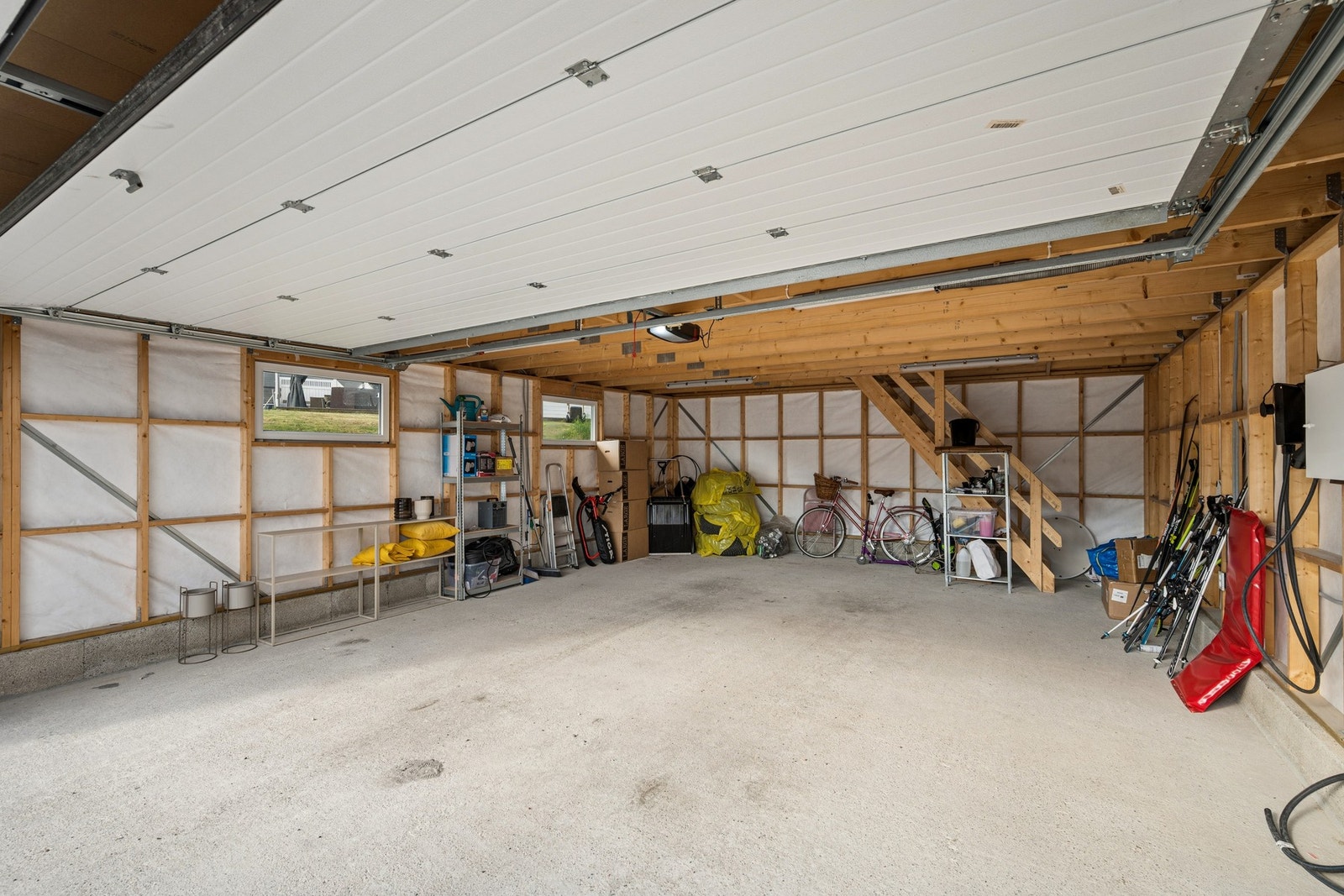 Romslig garasje på 47 m², bygget i 2021. Her er det innlagt strøm og trapp opp til hems for lagring. Galleribilde