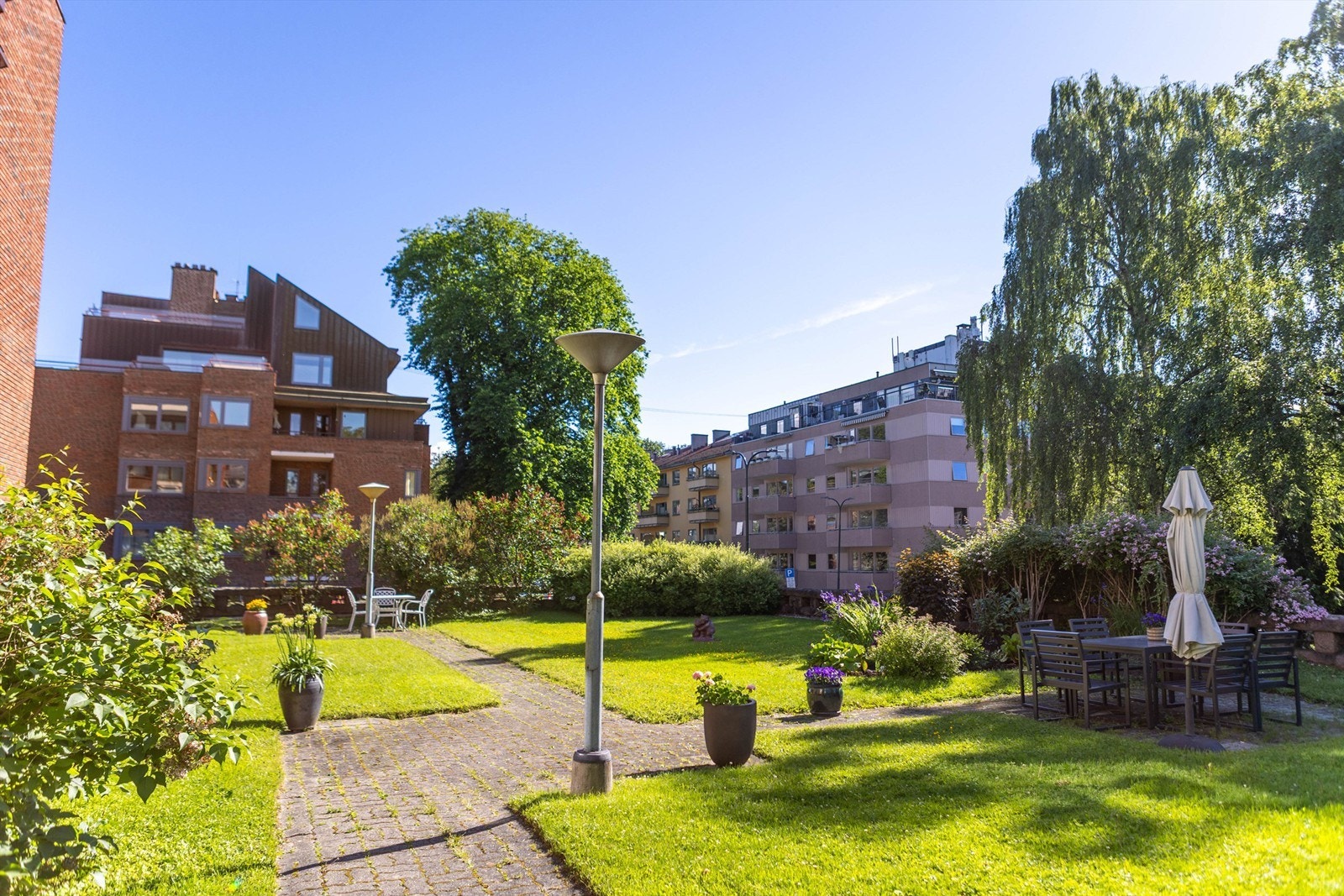 Felleshagen er pent opparbeidet med flere sittegrupper som inviterer til rolige stunder utendørs. Galleribilde