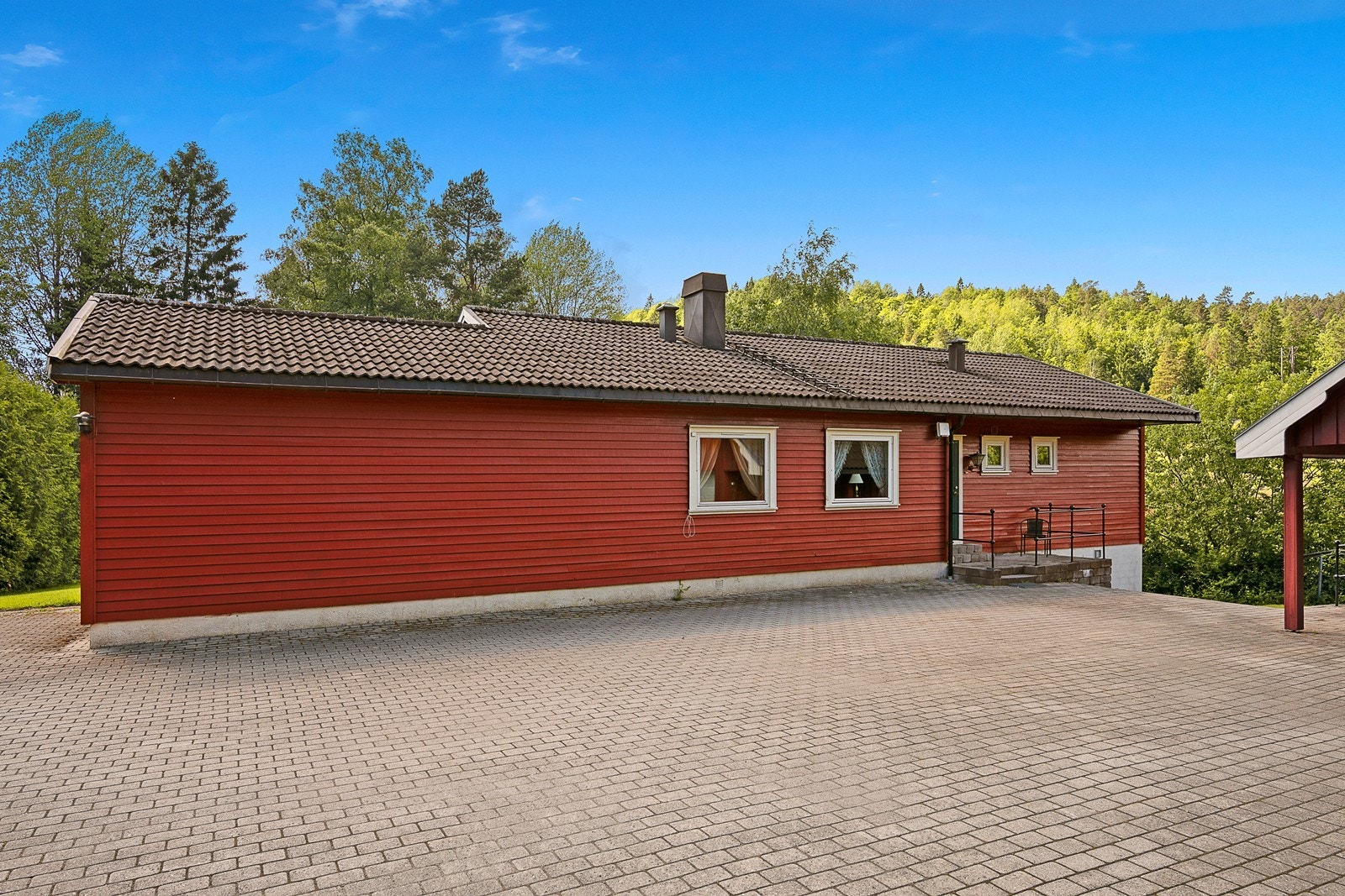 Ved inngangsparti er det en svært stor gårdsplass med belegningsstein samt romslig enkelgarasje med plass til både bil og lagringsplass. Galleribilde