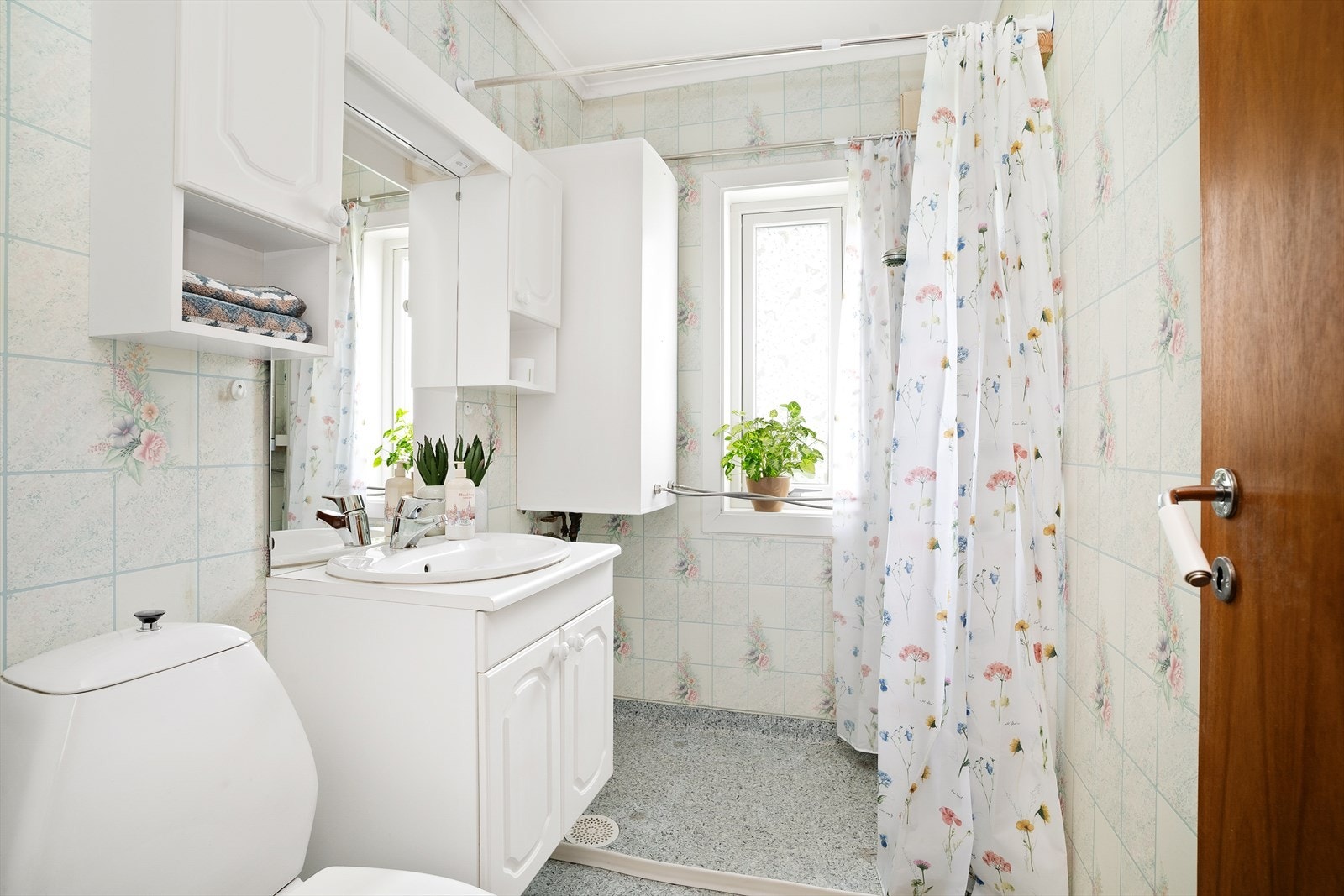 Badet i første etasje er et eldre, funksjonelt rom med dusjnisje, servant i innredning og toalett. Galleribilde