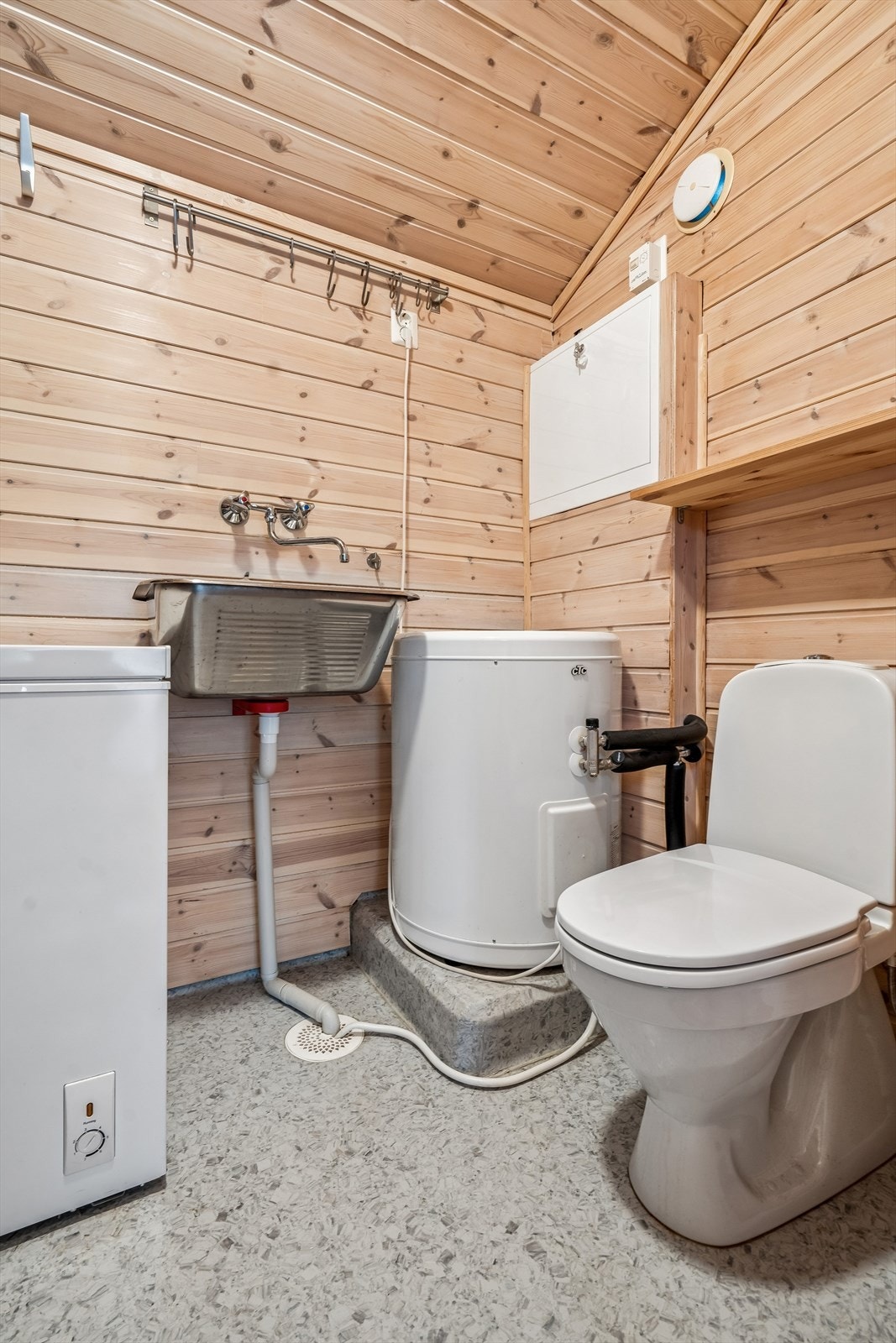 Praktisk rom innredet med toalett, utslagsvask og opplegg for vaskemaskin. Galleribilde