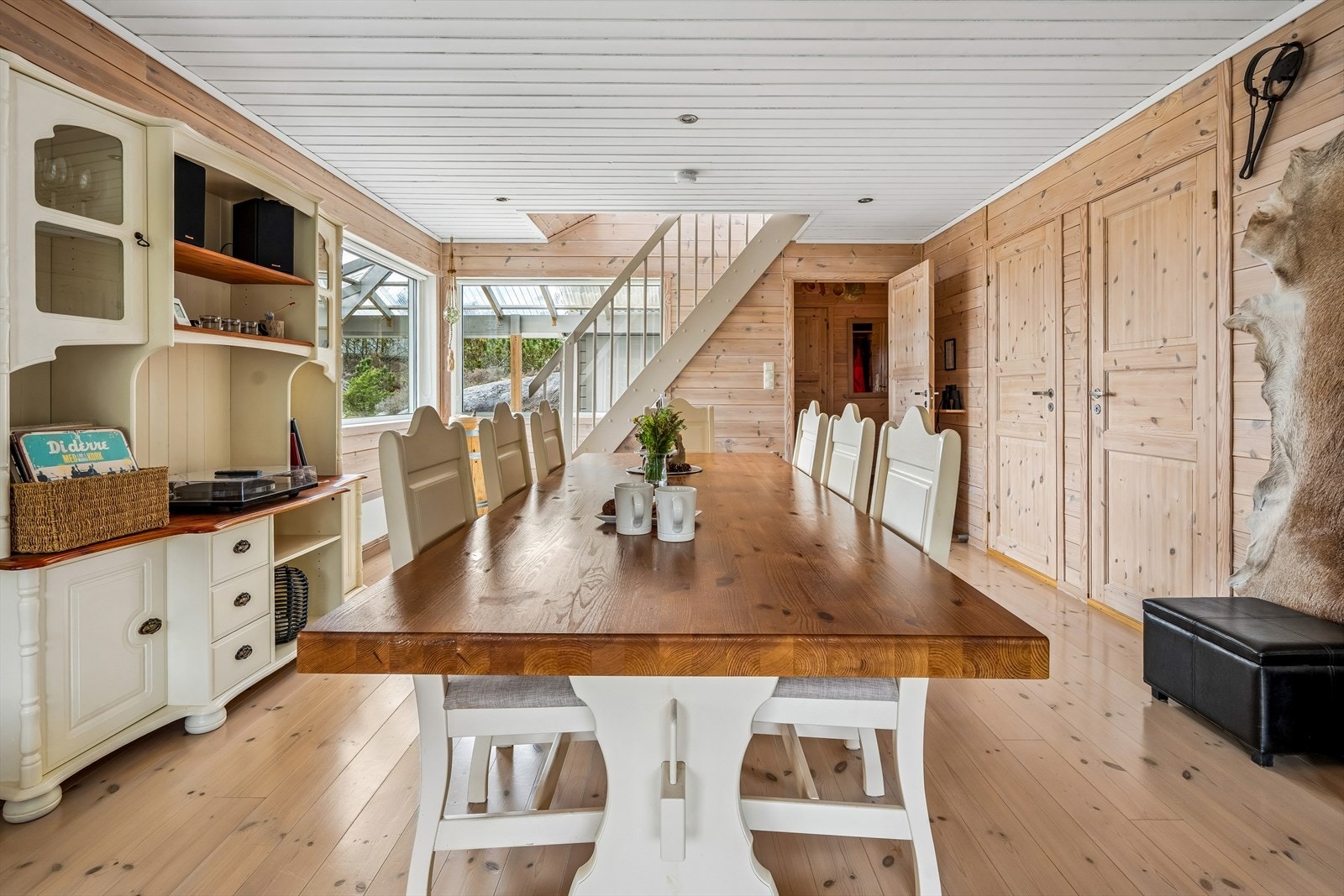 Spisestuen har plass til et stort langbord for felles måltider. Hytten selges møblert og er klar til bruk. Galleribilde