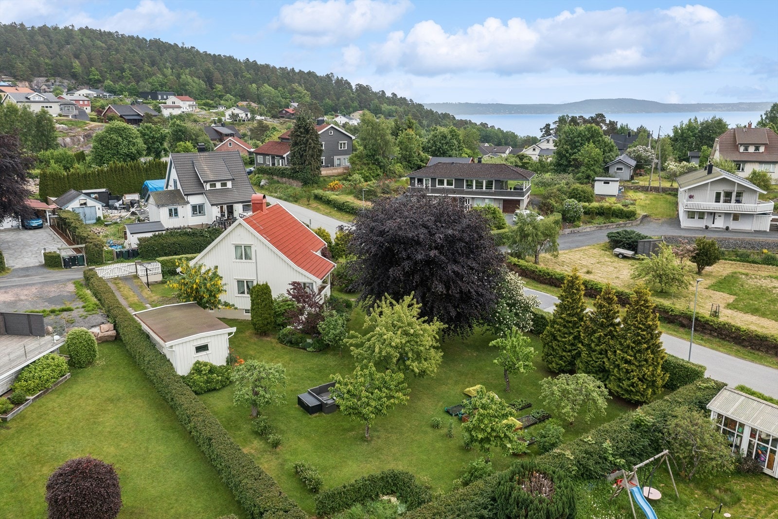Boligen er omkranset av grønne og frodige omgivelser. Galleribilde