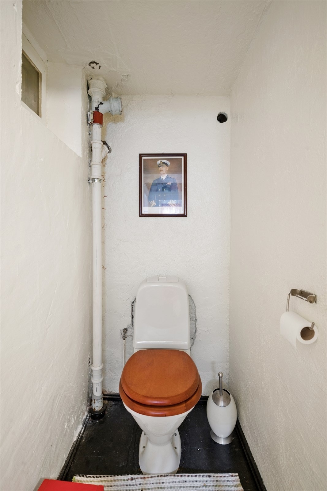Praktisk toalettrom i kjelleren, med enkle overflater fra byggeperioden. Galleribilde