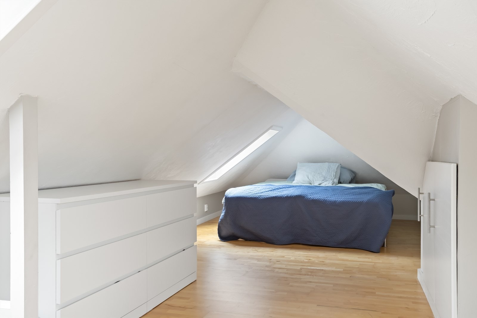 Loftsetasjen er innredet med seng, kommoder og praktiske oppbevaringsmuligheter under skråhimlingen. Veluxvinduer gir godt lysinnslipp og hyggelig utsyn. Galleribilde