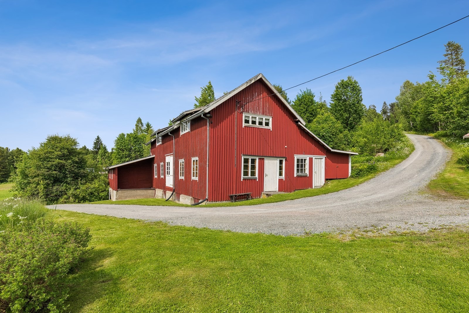 Eiendommen består av en enebolig, et stort verkstedbygg og en garasje, på en skrånende og terrassert tomt. Galleribilde