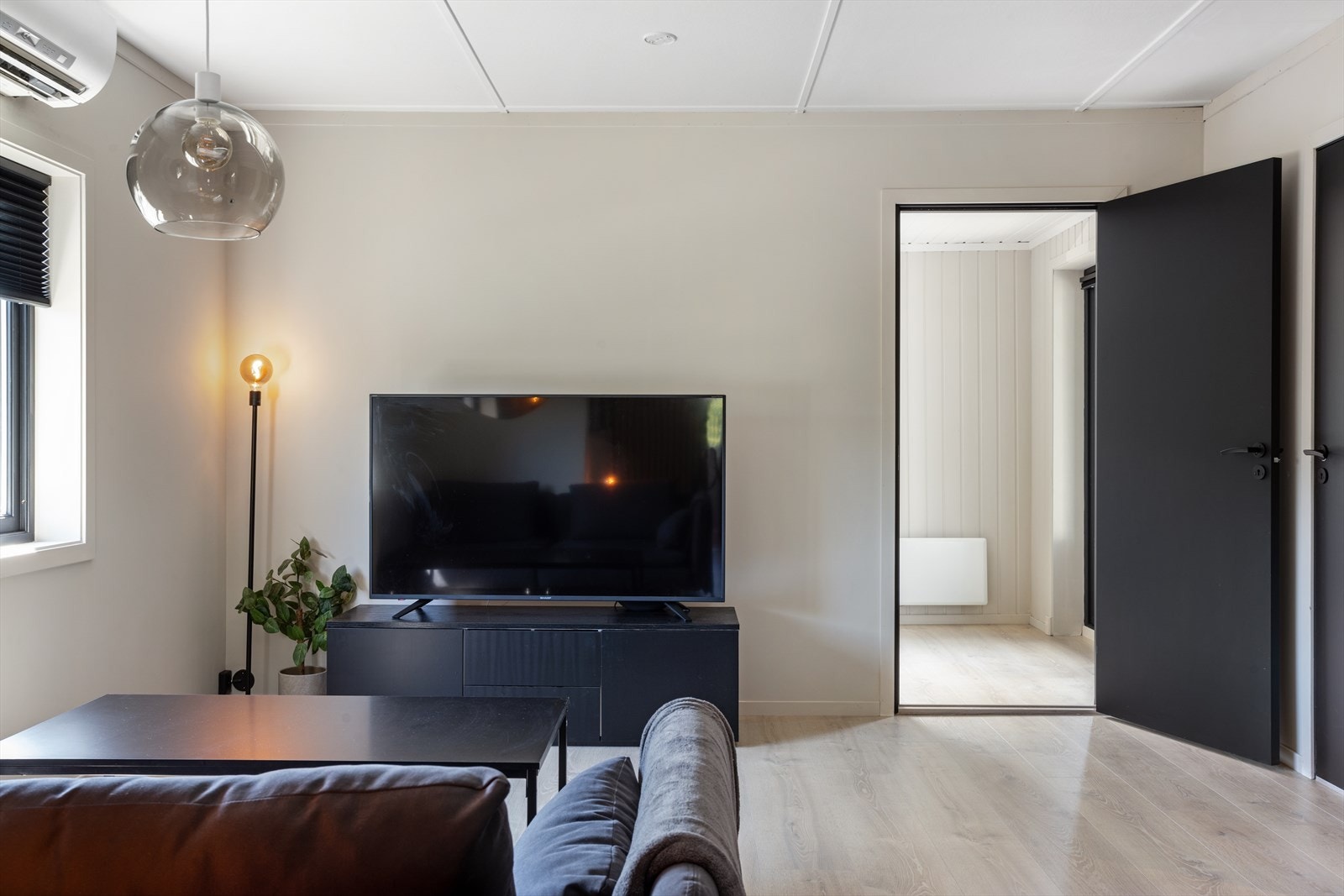 Stuen har naturlig plass til en mindre sofa og TV-møblement. I rommet er det installert en varmepumpe fra 2011. Galleribilde