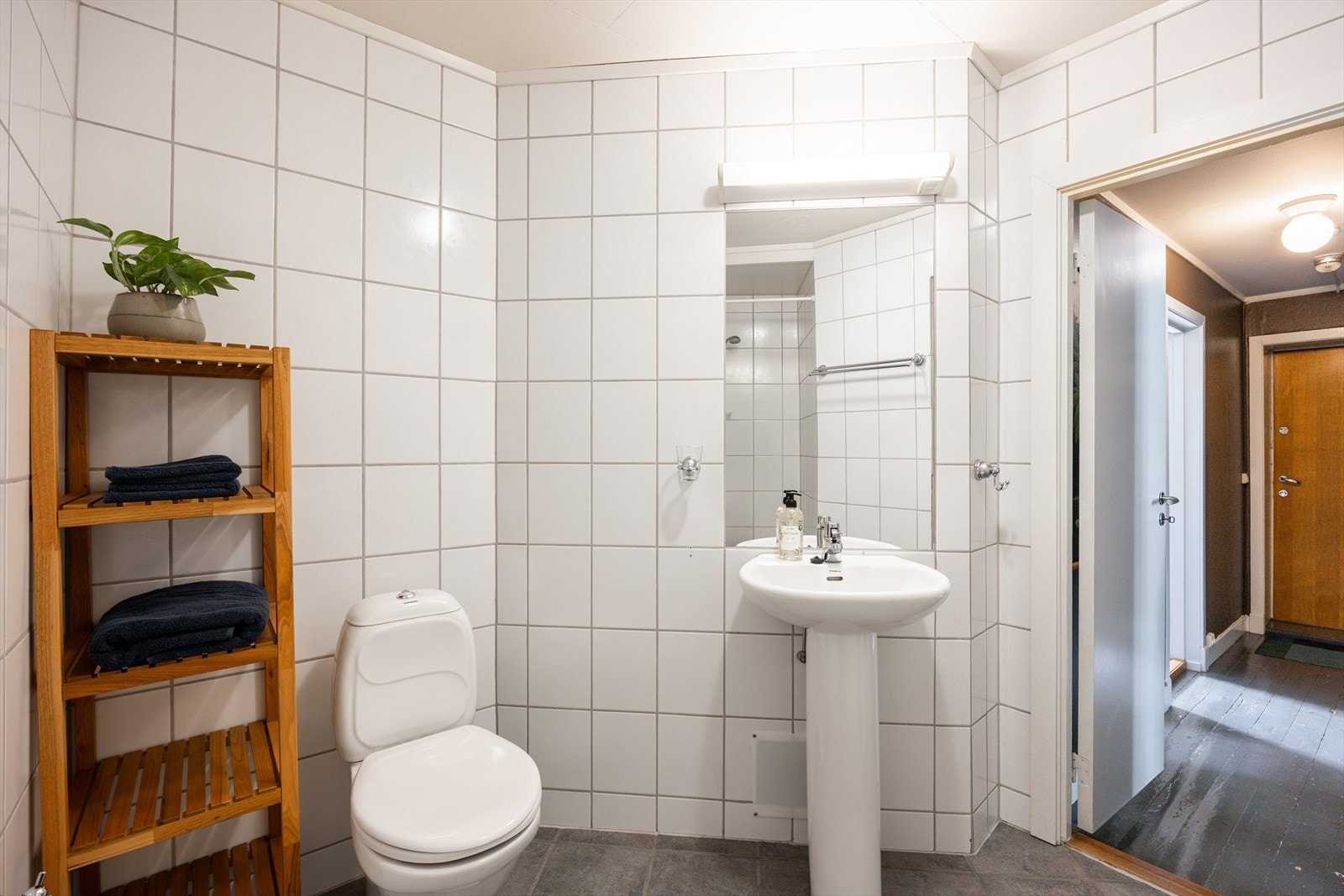 Badet har frittstående toalett og servant, samt god plass til oppbevaring Galleribilde