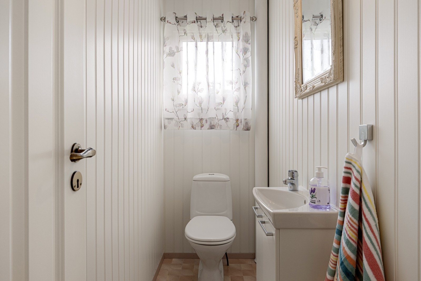 Vegg-i-vegg med badet ligger dette praktiske wc-rommet, som har gulvstående toalett og servant over skapseksjon. Galleribilde