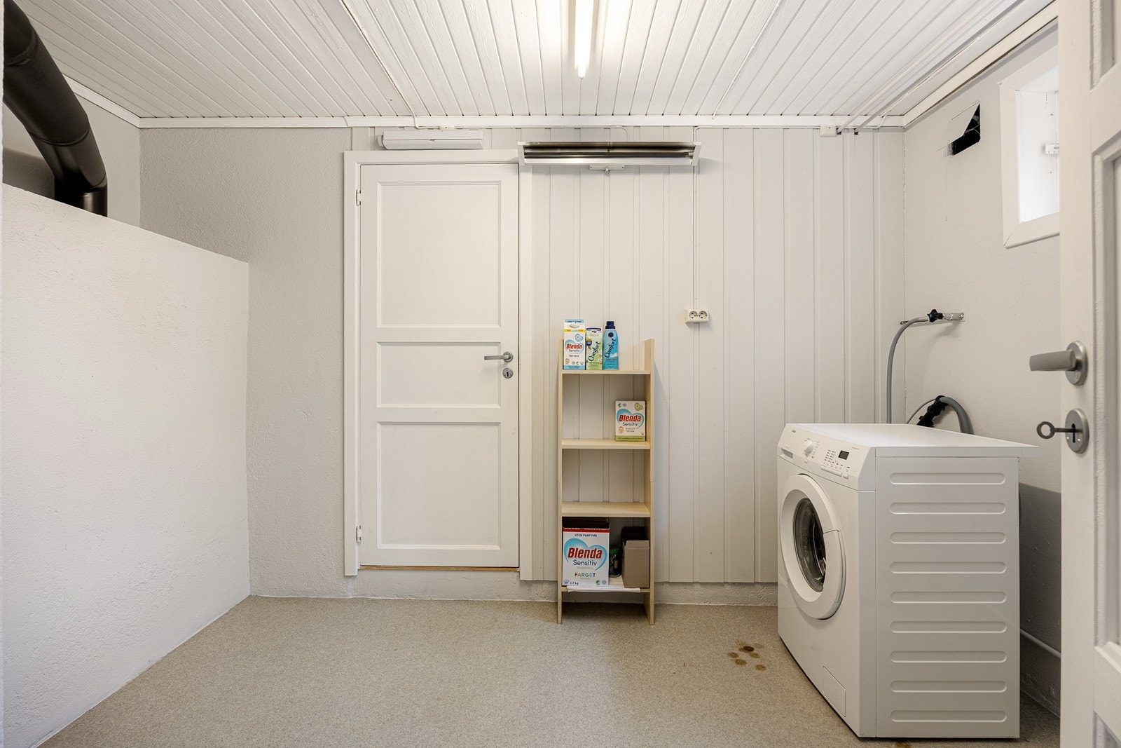 Vaskerommet har vegger med malt mur og panel, og på gulvet er det vinylbelegg. Videre er det skyllekum og opplegg for vaskemaskin. Galleribilde
