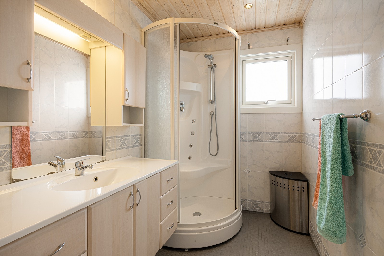 Badet har våtromsplater på veggene og fliser på gulvet med lun, behagelig varme under. Videre er det dusjkabinett og mekanisk avtrekk. Galleribilde