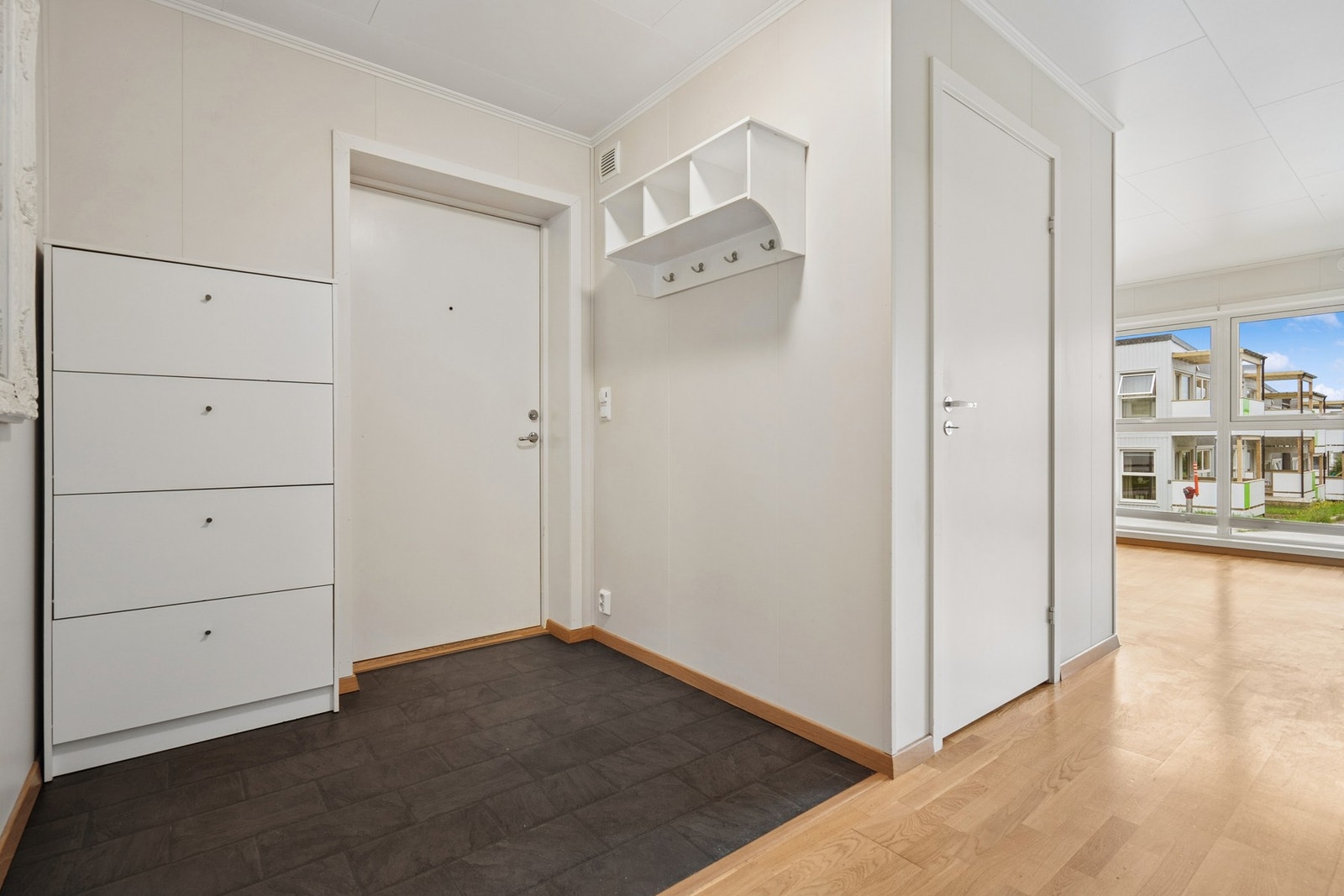 Entrè med fliser på gulv og plass til oppbevaring av yttertøy og sko. Galleribilde