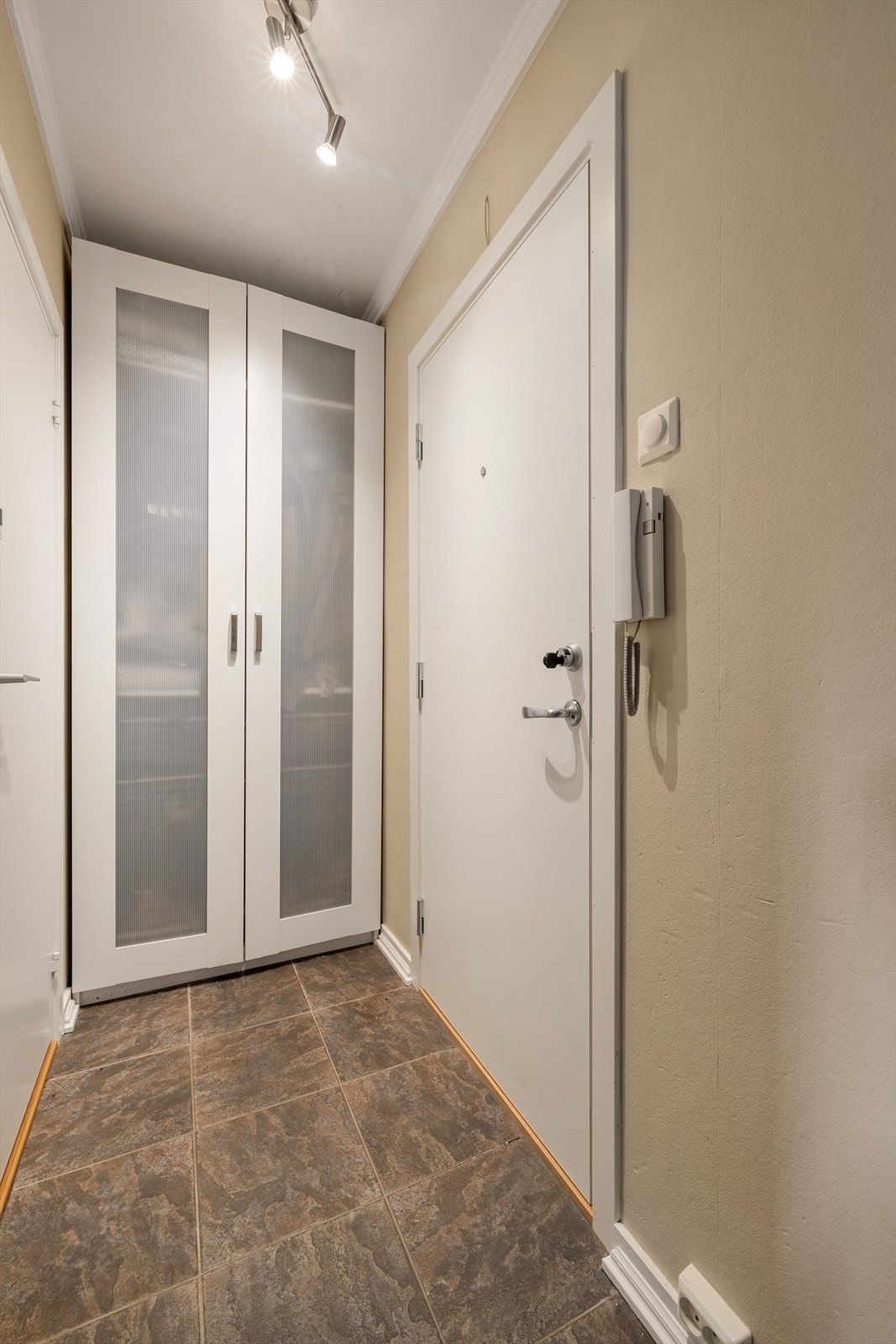 Entré med praktiske fliser på gulv, og godt med oppbevaringsplass i garderobeskap Galleribilde
