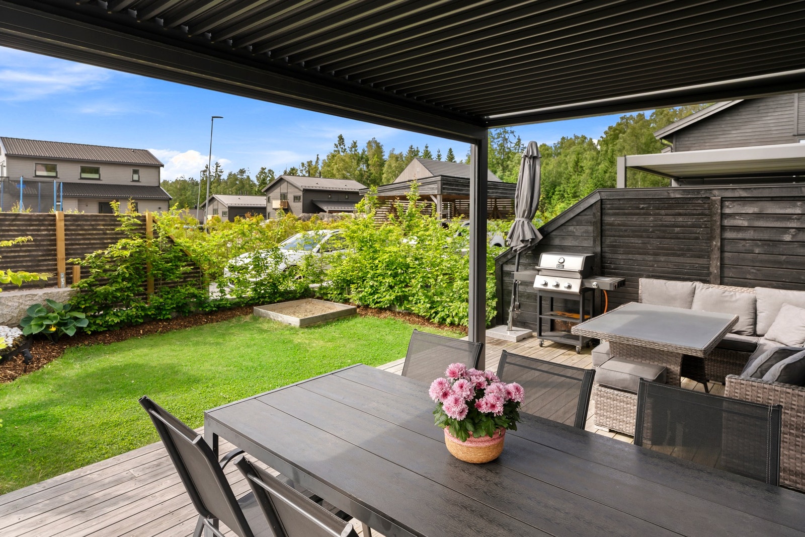 Hagen er pent opparbeidet med gressplen og beplantninger. Galleribilde
