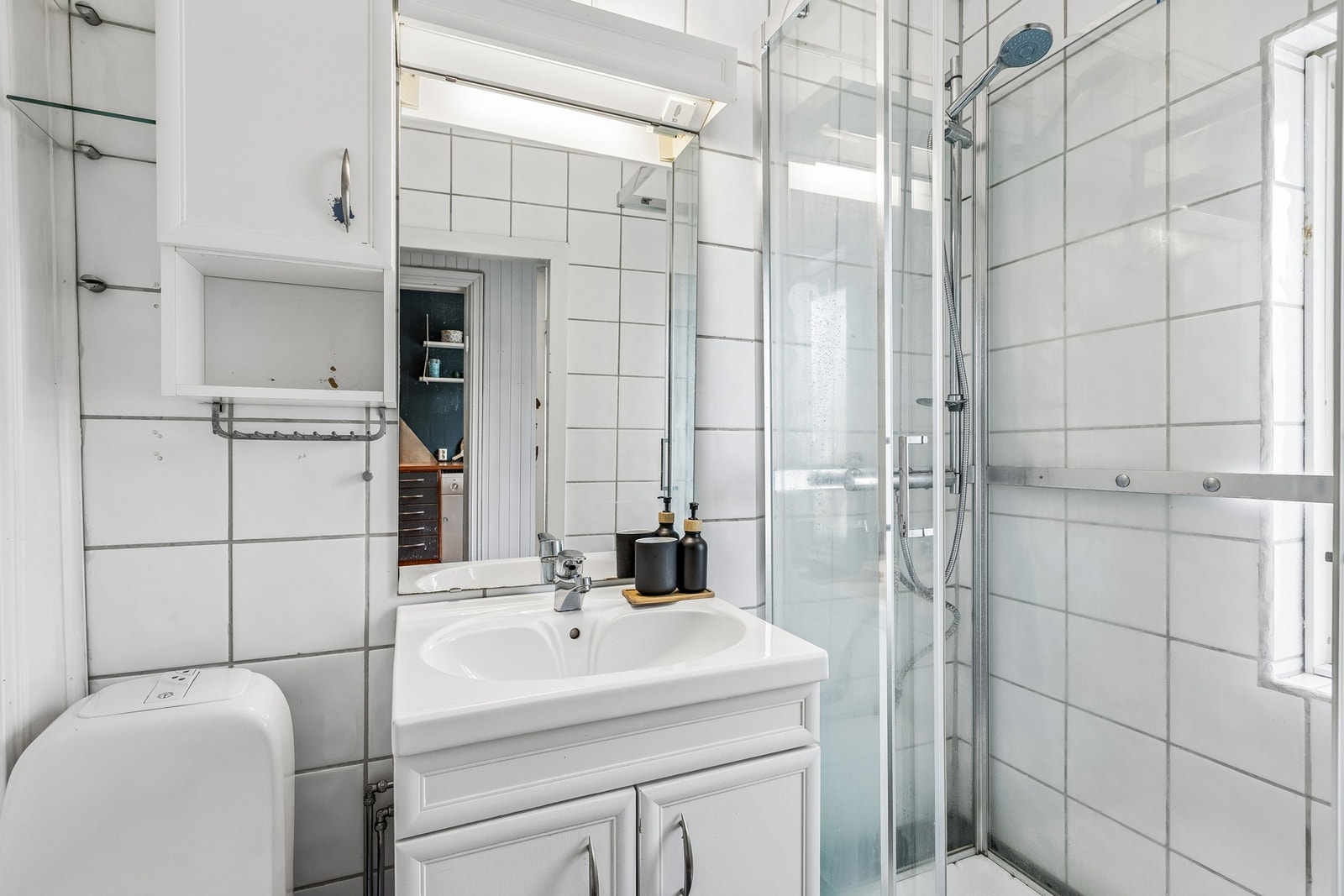 Badet er oppgitt til 2,3 m² med flislagte overflater, gulvvarme, servantinnredning, speil/overskap, gulvmontert toalett og dusjkabinett. Galleribilde
